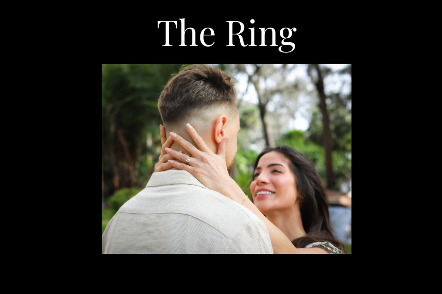 A woman hugs a mans neck with her hands. Her diamond ring glistens in the sunlight.