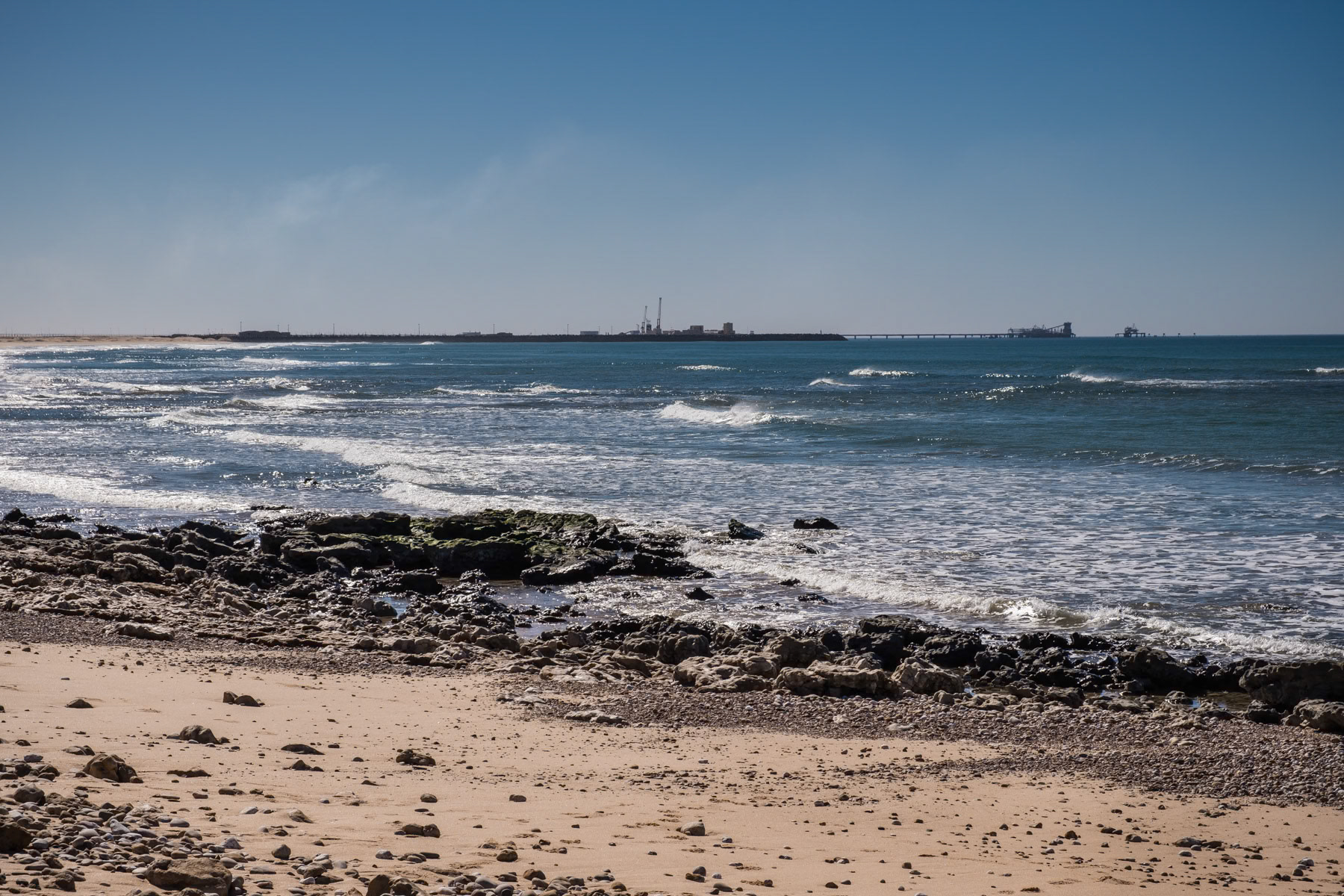 The South Atlantic Ocean with the port of Laayoune in the background. Dispite being a disputed territory, the Western Sahara's mineral resources are being vastly exploited and exported. China is one of the main investors in the area. Laayoune, Western Sahara, December 2018
