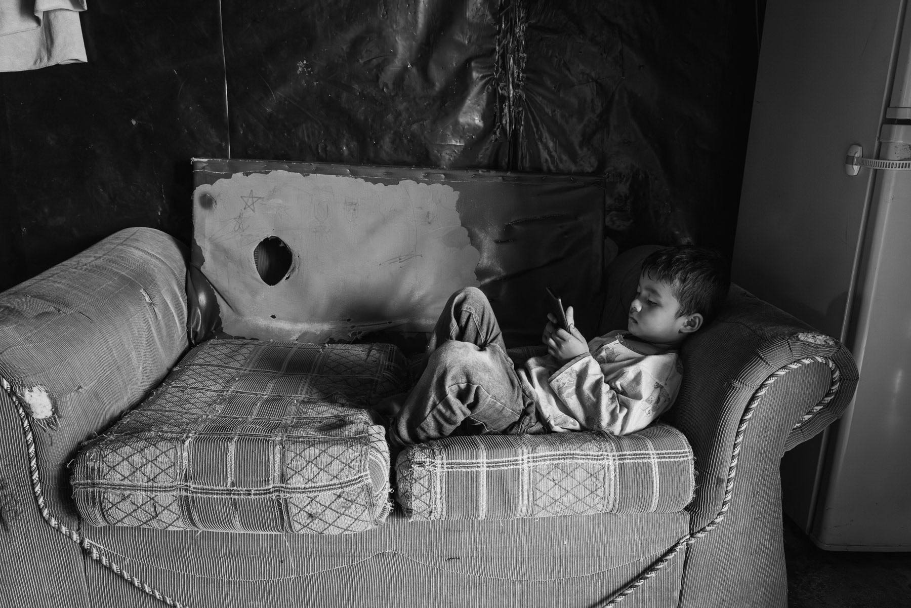 Child from the Chin community in Kampung Raja where his parents work up to 12 hours a day in farms earning very low salaries and at risk of being arrested for working while being refugees. Cameron Heighlands in Pahang, Malaysia, May 2024