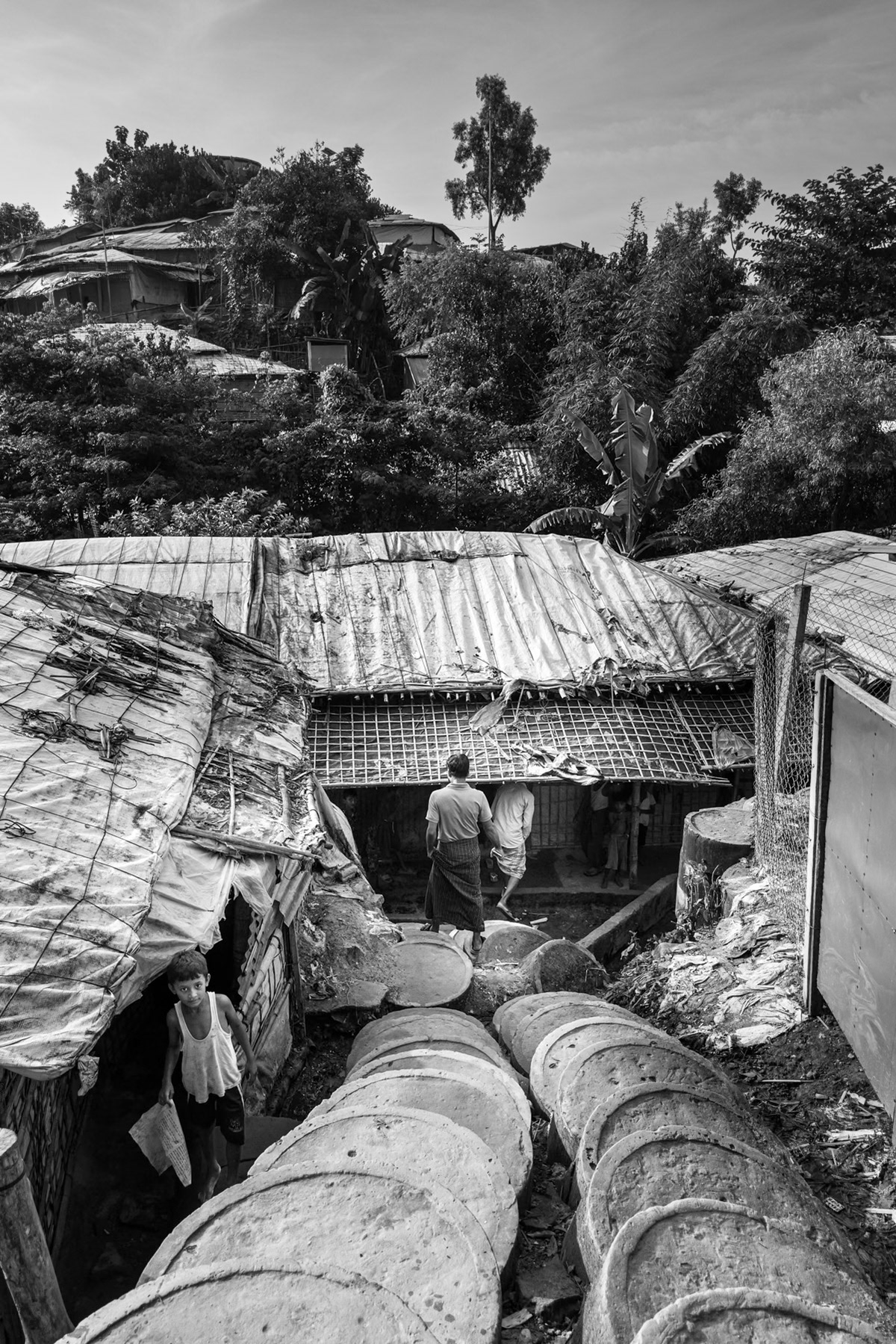 Concrete-lined stairs wind through makeshift shelters on the steep hills of the camp, where densely packed structures are highly vulnerable to landslides during the monsoon season. Kutupalong refugee camp, Ukhiya, Bangladesh, September 2025
