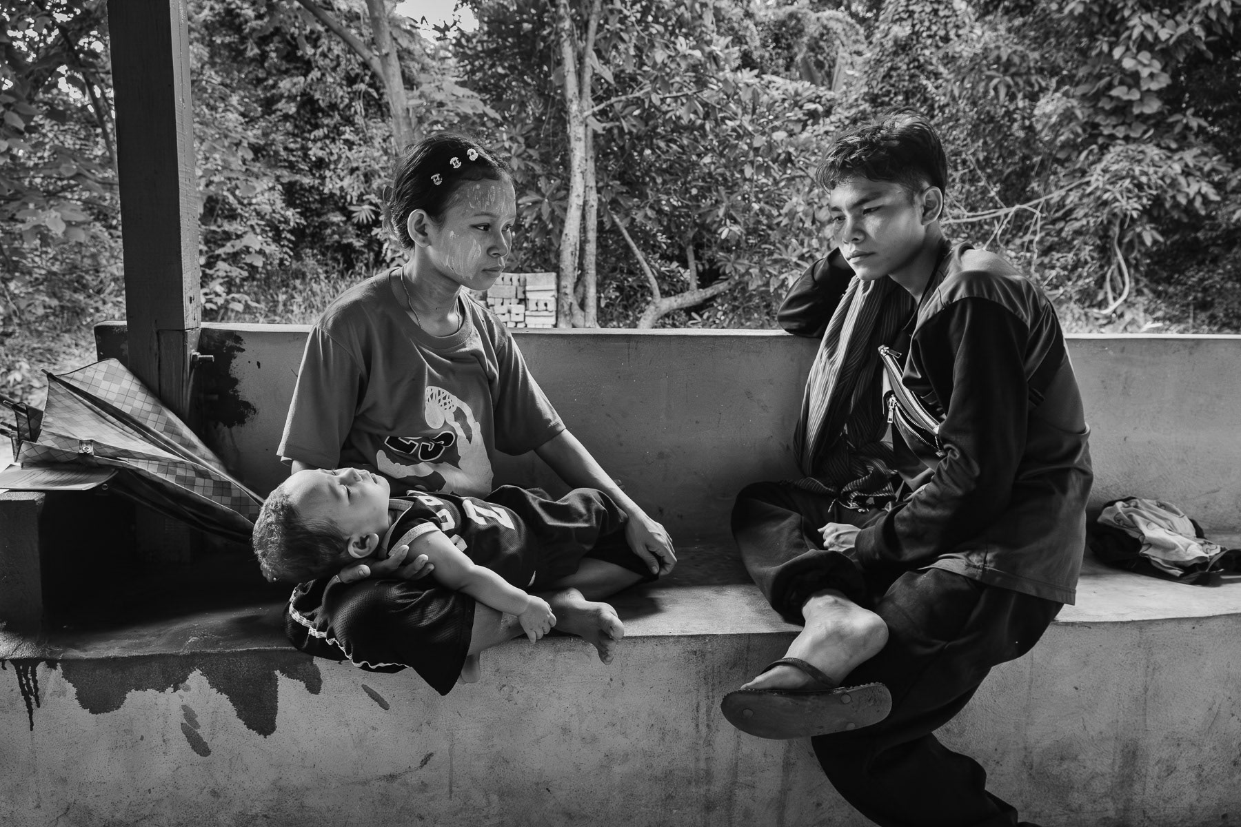 A young couple coming to a clinic with their young child who has high fever. Lae Gho clinic, Karen State, Myanmar, September 2024