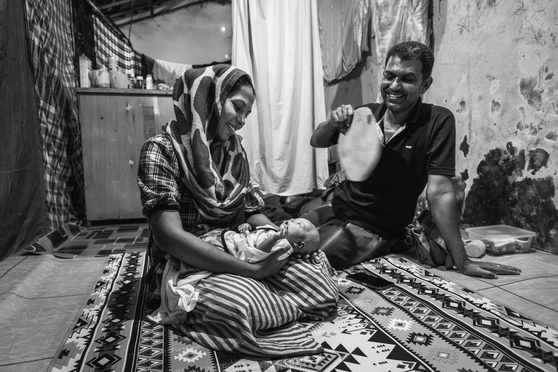 Rohingya woman from Sittwe in Myanmar and her newborn child and husband in a shelter for Rohingya refugees that were trafficked by boat and stranded along the coast of Sumatra in Indonesia. Padang Tijie shelter for Rohingya refugees, Aceh, Indonesia, May 2024