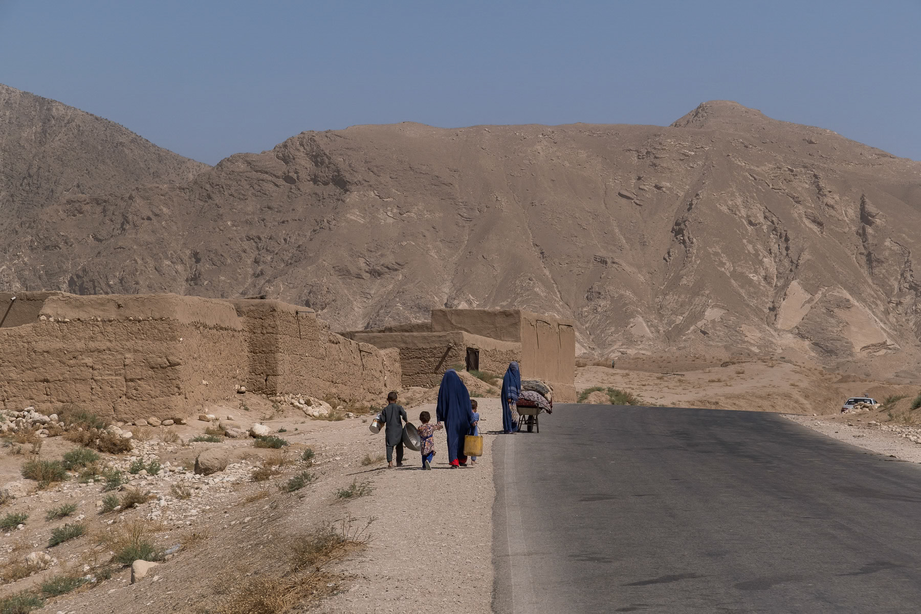 Afghan women wearing the 'Chaador' and their children carrying belongings. Since the Taliban take over of the country, endless restrictions have been placed on women, banning them from education, work, cultural activities and basically the streets where they should be accompagnied by a male guardian. Afghanistan under the Taliban has become a 'no woman's land' and a gender apartheid system. Buina Qara, Balkh province, Afghanistan, September 2024