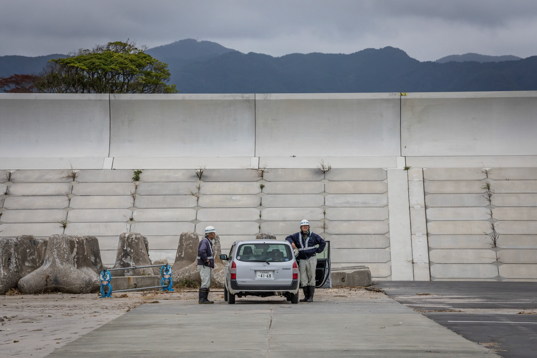 Construction workers involved in building sea wall along the coast in order to limit the catastrophic effects of a tsunami. Also the sea wall is built to protect the affected nuclear power plants along the coast that will require many years to be fully decommissioned. Tomioka Fishing port, opened in July 2019. Tomioka, Fukushima Prefecture, Japan, October 2019
