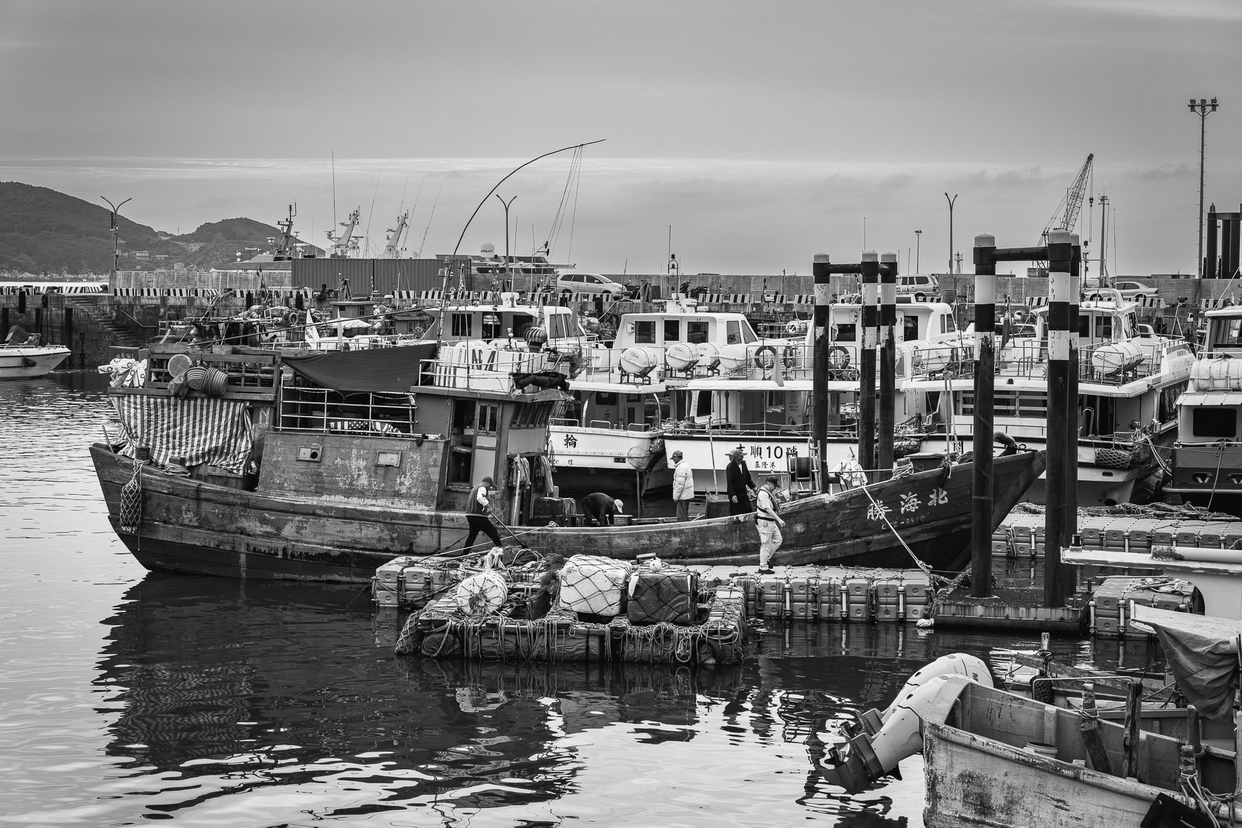 With the coast guard's sign-off, fishing boats in Matsu's port, crewed by many Indonesian fishermen, are cleared to unload. Nangan port, Matsu Islands, Taiwan, May 2025