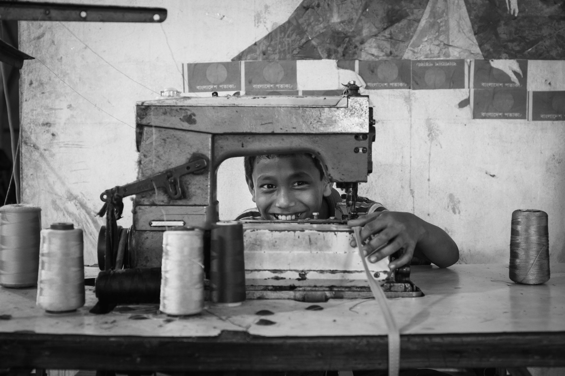 Child working in a garment factory producing pants for the local market. Garment industries that do not export tend to fall out of the control of child labour inspections. Controls that are gradually being put in place in other garment factories that exclusively produce clothing for the large international brands. Dhaka, Bangladesh, May 2015