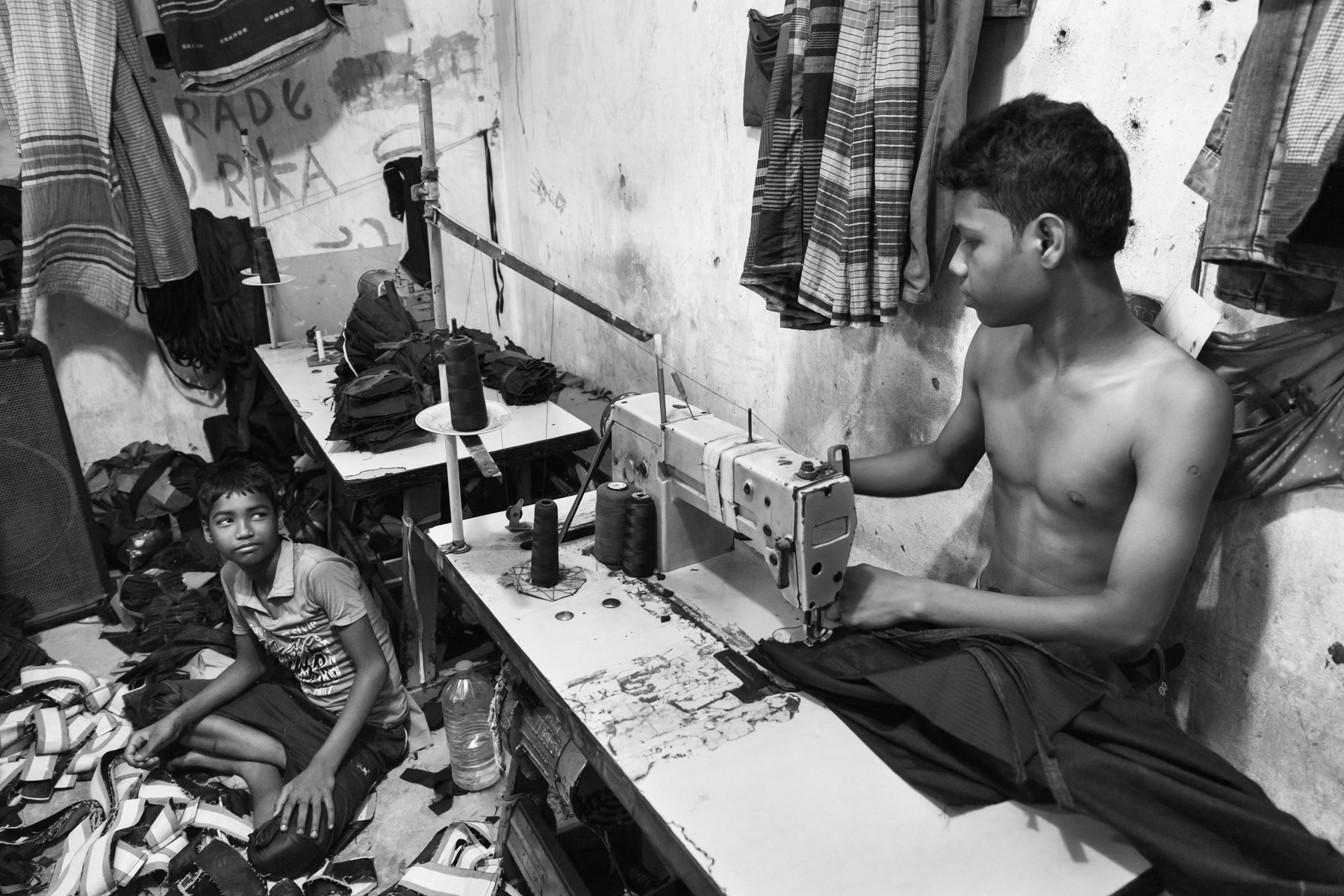Teenagers producing pants in a local garment atelier in Dhaka, Bangladesh, May 2015