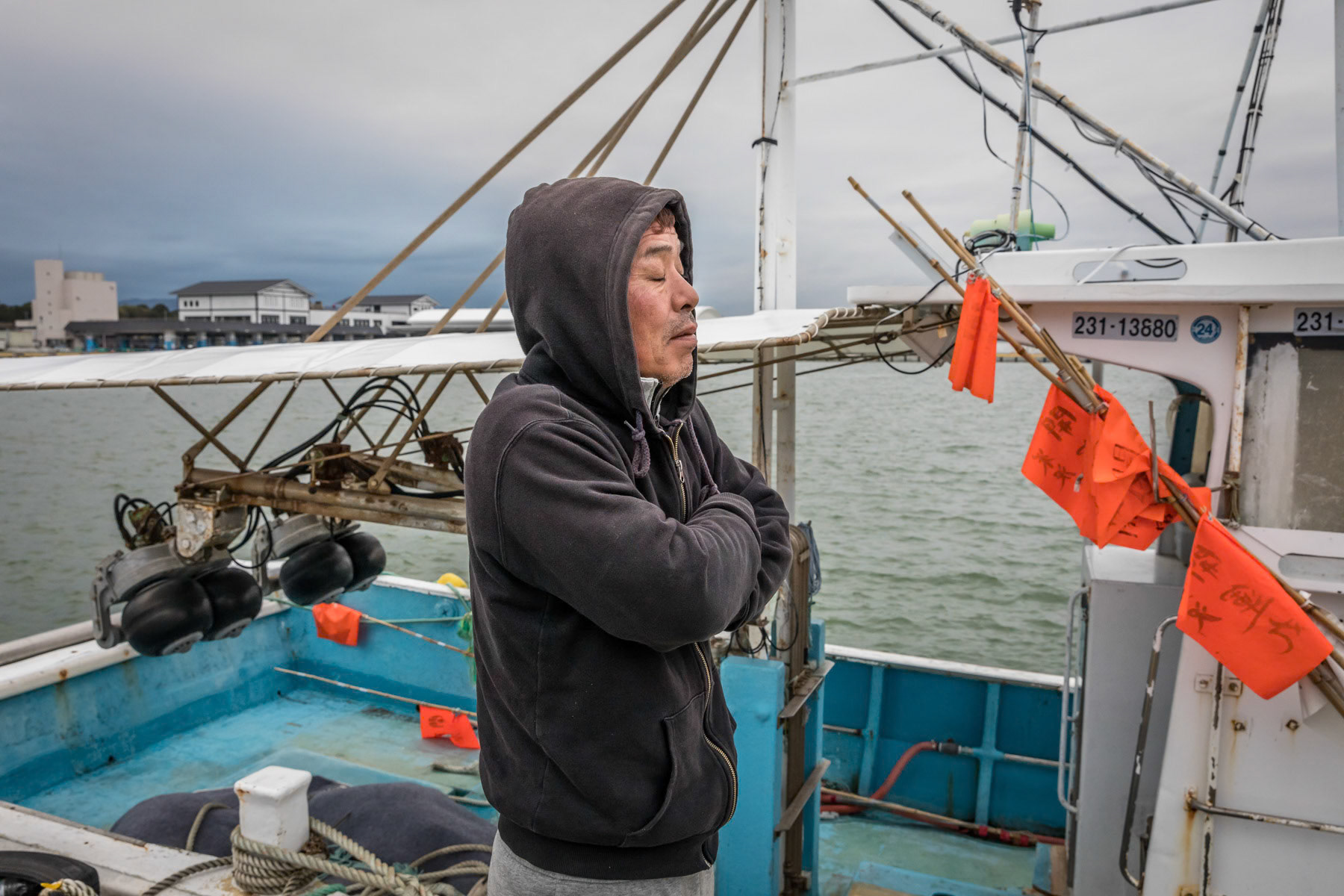 A fisherman and his newly aquired boat. The fishing community has been gravely affected by the Tsunami and many died trying to save their boats. The surviving fishermen have been banned from fishing for many years after the nuclear catastrophy. Only in the past couple of years has fishing being allowed again under very stringent radiation controls. Soma fishing port, Fukushima Prefecture, Japan, October 2019