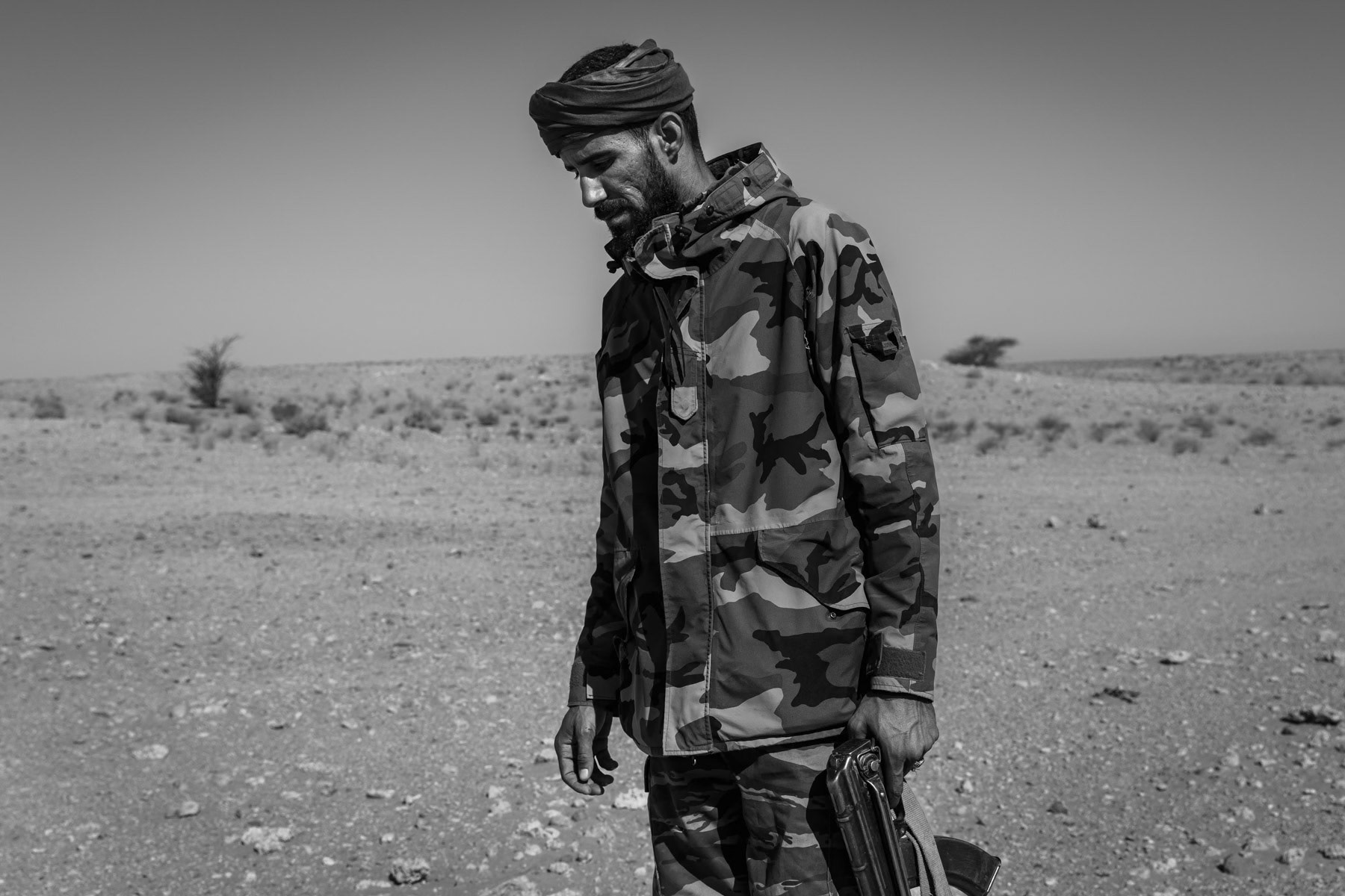 Sahrawi soldier near the frontline and the 2,700 km long sand berm, built by Morocco, dividing the Western Sahara between the Moroccan controlled territories and Sahrawi liberated territories. Undisclosed location behind the frontline in the liberated Sahrawi territories, Sahrawi Arab Democratic Republic, October 2021