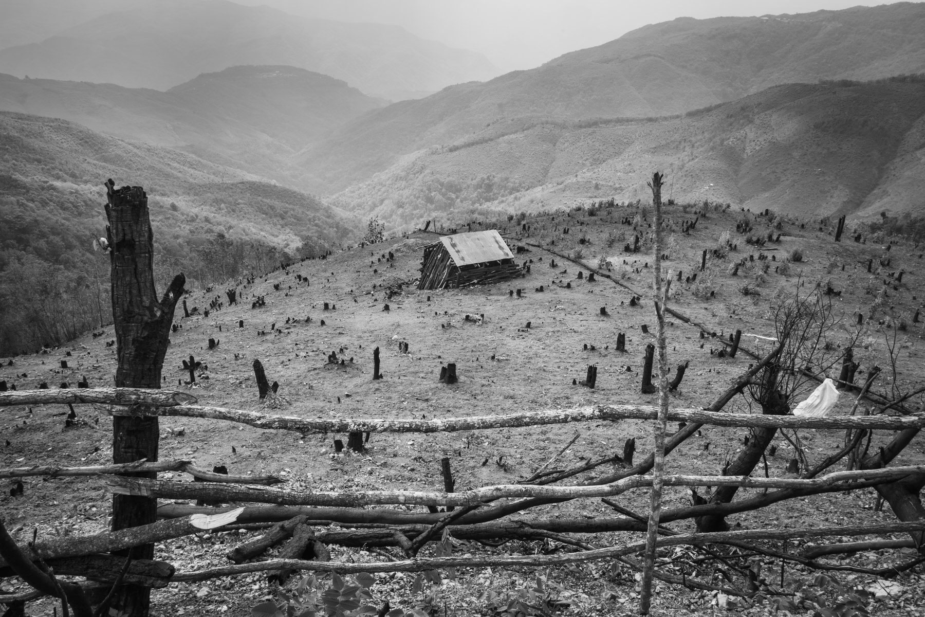 Deforestation and land burning for agriculture purposes around villages in Chin State. The land is equally distributed among the families of the villages and every year there is a land rotation system so that the soil has several years to regenerate before it is being cultivated again. However because of the mountainous terrain and rainy season, landslides do occur regularly. Falam township, Chin State in Myanmar, June 2023