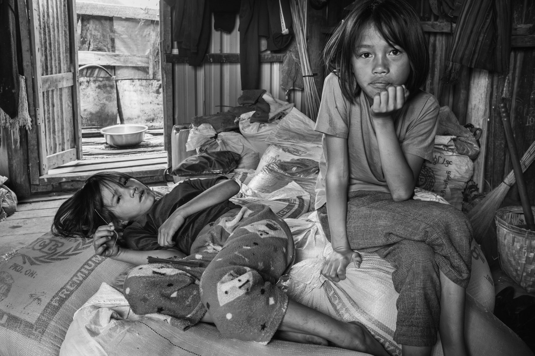 Two sisters displaced from Thantlang, a town that has been totally destroyed and where heavy fighting between the Chin National Army and the Myanmar military is ongoing. The villages around Thantlang township where most people took refuge are also unsafe and frequently targetted by airstrikes. Thangklua village near Thantlang, Chin State, Myanmar, June 2023