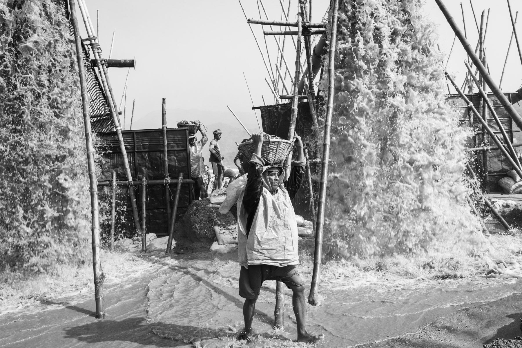 Stone carriers under an extraction pump in the Dholai river in Bholaganj, Bangladesh, December 2015