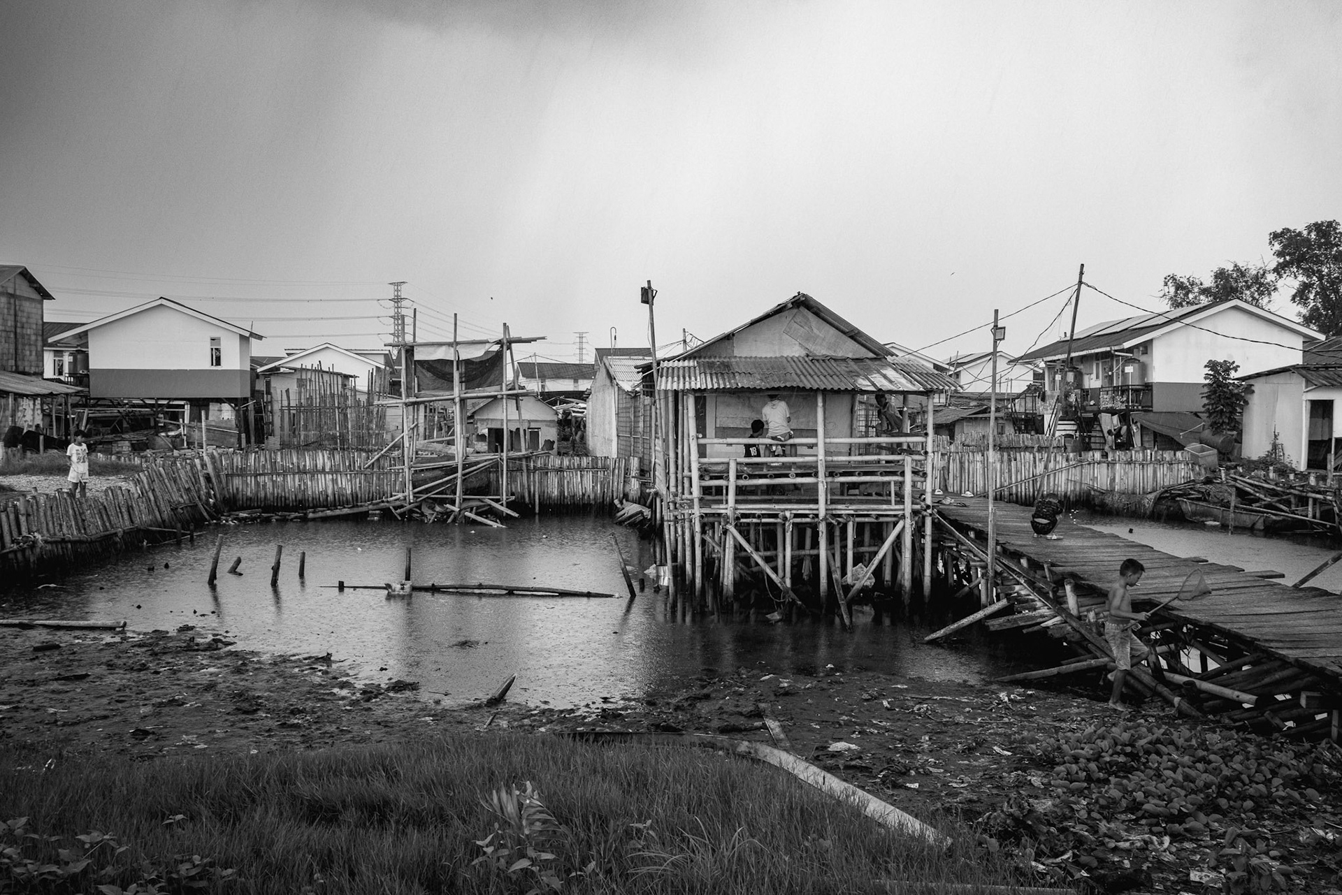 In Muara Angke, traditional stilted dwellings are no longer enough. The community is caught in a cycle of constant modification, extending structures upward and outward as the harbor floor continues to settle and the water levels climb. Jakarta, January 2026