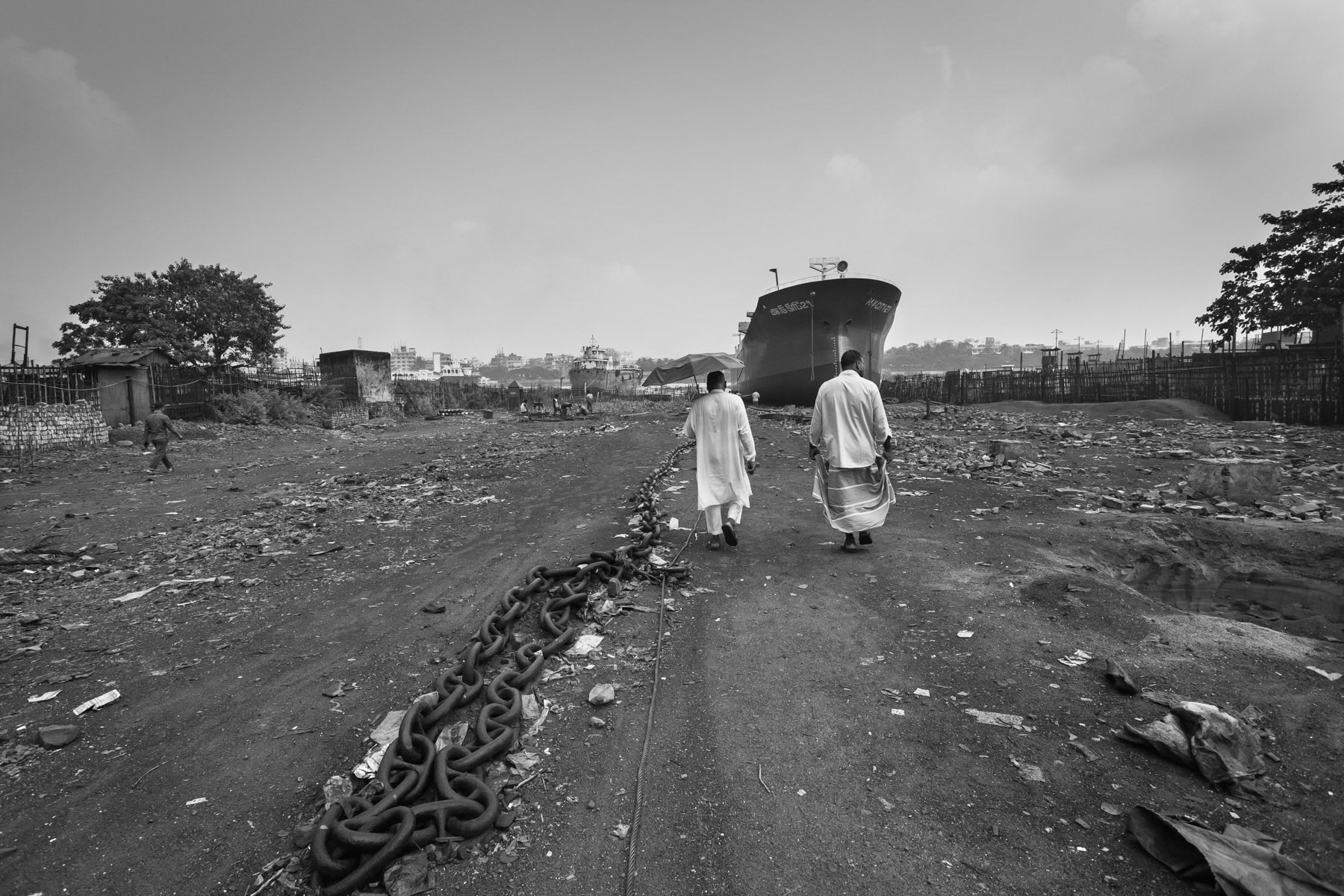 Shipyard owner and client watching the boat being pulled manually in the river. Dhaka, Bangladesh, October 2014