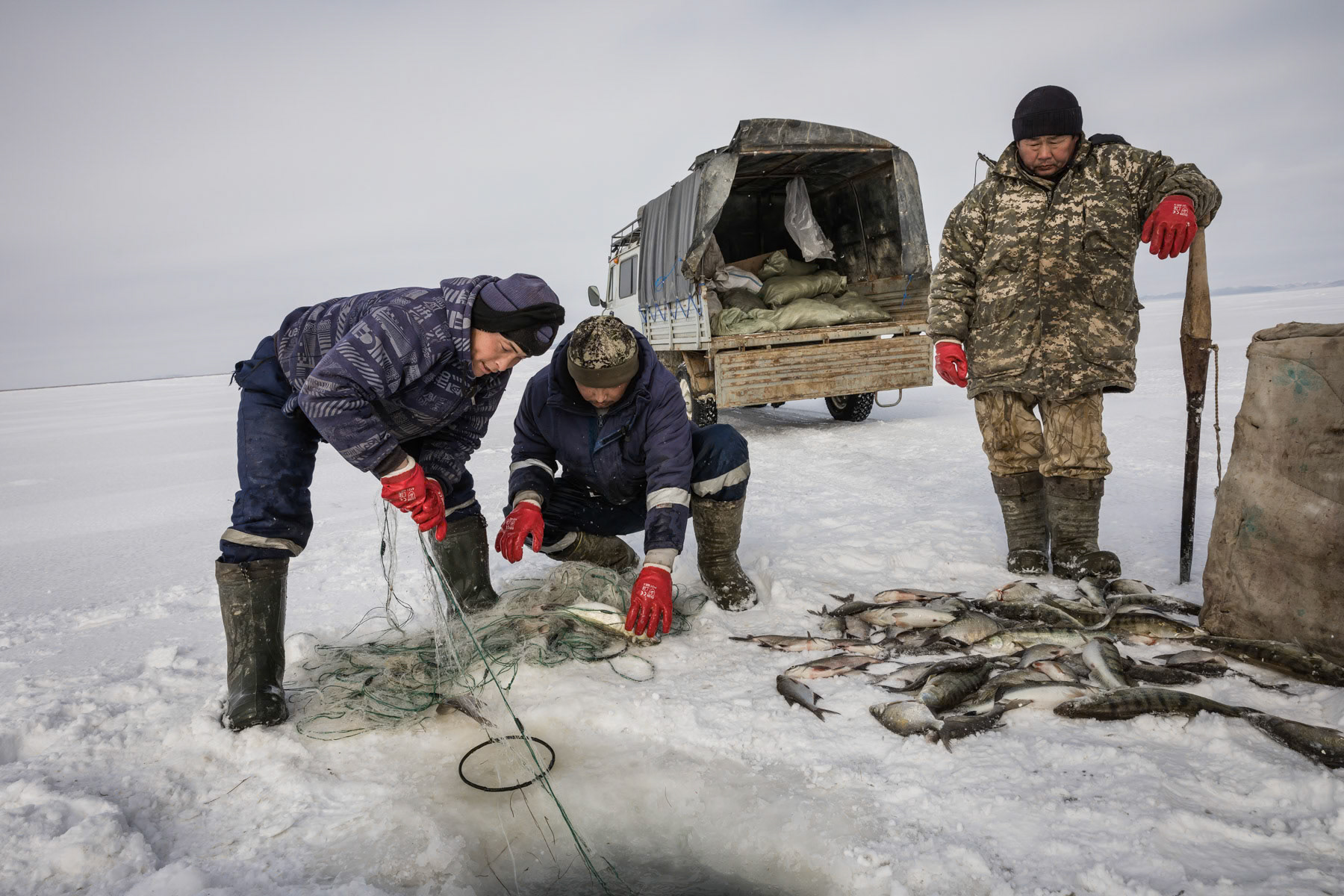 Fishermen at work on the Aral Sea during the ice fishing season. Kazakhstan, January 2019
