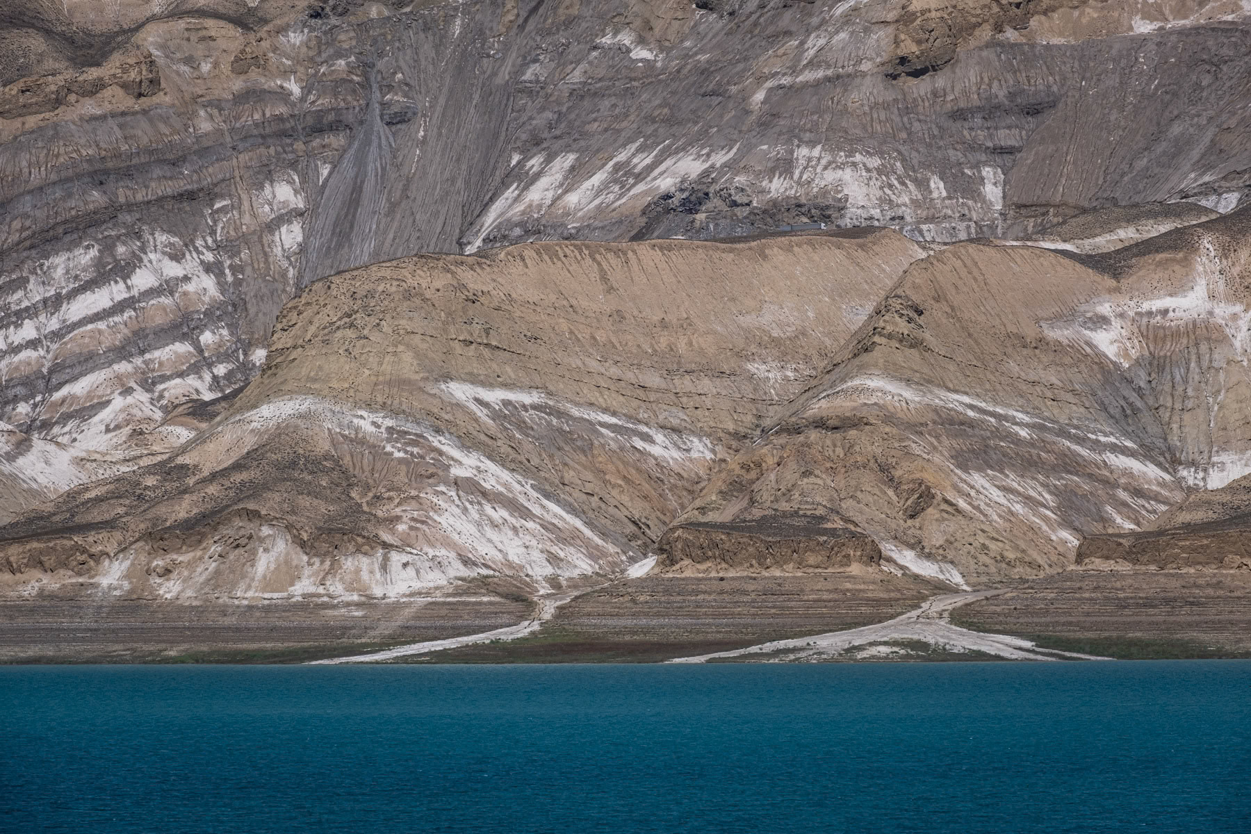 Toktogul Reservoir on the Naryn river showing alarming low levels following persistent droughts in Central Asia. The hydro electrical power stations on the Naryn river and the Toktogul reservoir are crucial for Kyrgyzstan's energy needs, but with longer and recurring periods of drought it becomes impossible to cater for an ever increasing population. The Naryn river, which in Uzbekistan will become the Syr Daria river and eventually flow into the Aral Sea, has an ever decreasing volume. Further accelerating the complete disappearance of the Aral Sea few thousand km away. Toktogul Reservoir, Kara Kul, Jalalabad region, Kyrgyzstan, August 2021