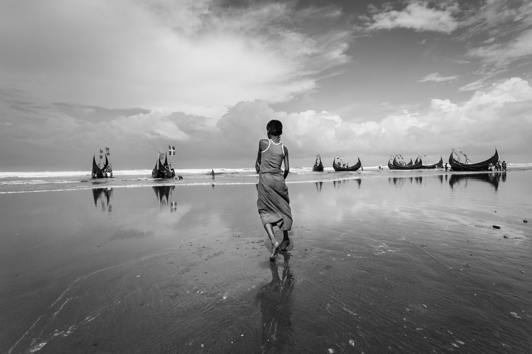 Rohingya working as low paid daily labour for Bangladeshi fishing boat owners. The same boats have been used to smuggle desperate refugees towards international waters where bigger boats wait to transport them towards Thailand and Malaysia. Recently similar boats have been used to flee from Myanmar to Bangladesh. Shamplapur, Bangladesh, June 2015