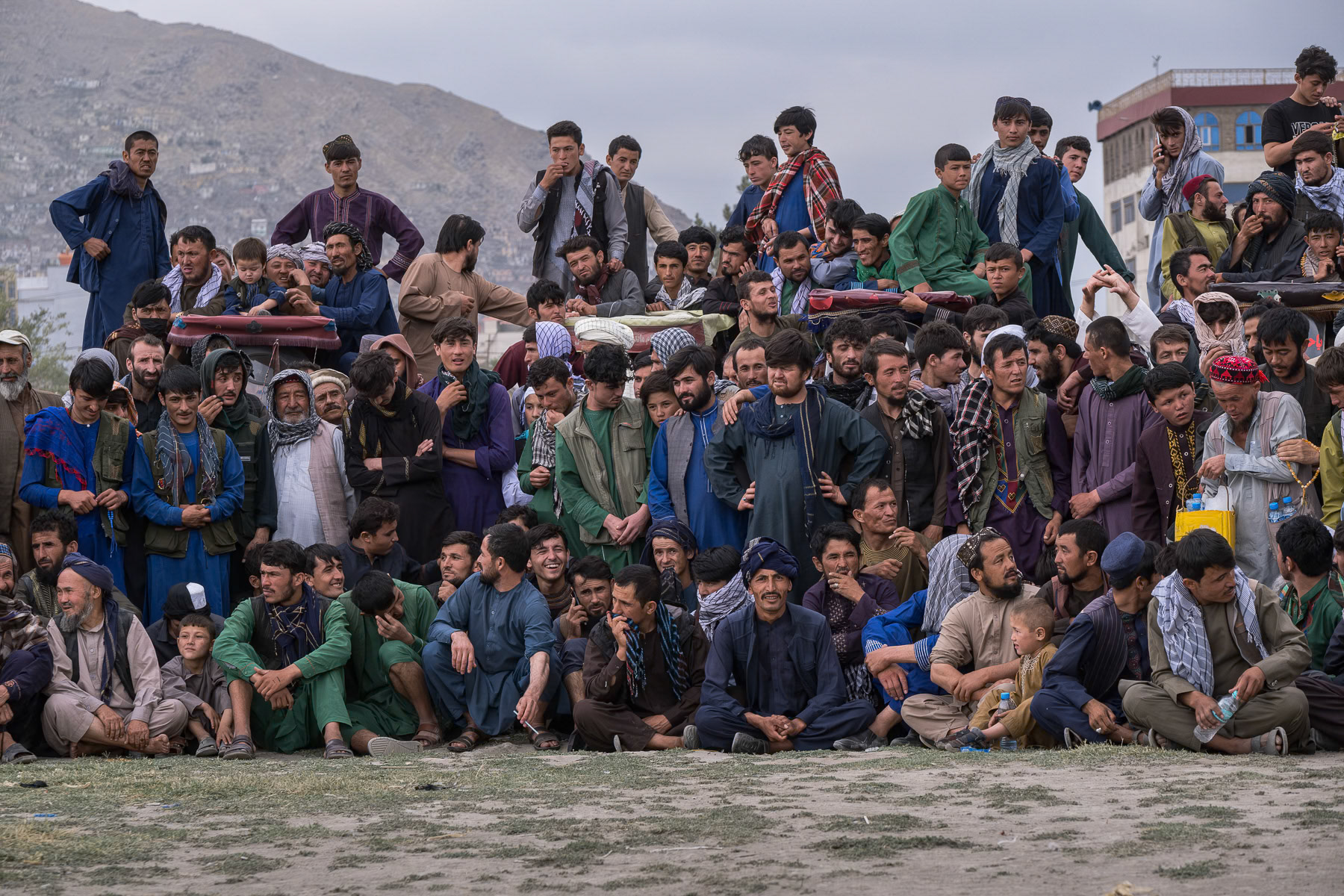 Afghan men attending wrestling games on a friday afternoon. Other games and leisure activities are available at this huge park in downtown Kabul, but only for boys and men as girls and women are banned from visiting public venues. Since taking over Afghanistan in 2021, the Taliban have relentlessly restricted women from being part of society by banning education, work and cultural activities. A de facto 'Nowomenland' and apartheid is being established. Chaman Hozori park, Kabul, Afghanistan, August 2024