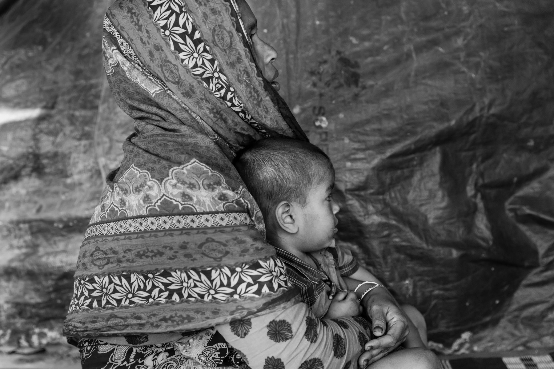 Rape victim, Sufia Khatun and her son from Chut Pyin, Rathedaung. She has 3 daughters, one daughter of 14 was gang raped and killed in front of her in the same room where she was raped, by military and local Rakhine which she can identify by name. She has 5 sons that were saved along with 2 of her younger daughters. Her husband was decapitated in front of them. She was gang-raped for a couple of hours by military and local mobs. The main local Rakhine rapists and killers were identified by her by their voice as she was blindfolded and tight while being raped and beaten. She was let go after giving all her gold jewellery and the equivalent of 500 usd in local currency. Two of her brothers and her sister in law were also massacred. Chut Pyin village is one of the numerous Rohingya villages that have been totally wiped out and where severe acts of ethnic cleansing with genocidal intend have been committed by the military and local mobs. Hundreds of Rohingya have been massacred in this village alone. Tangkhali camp, Bangladesh, March 2018