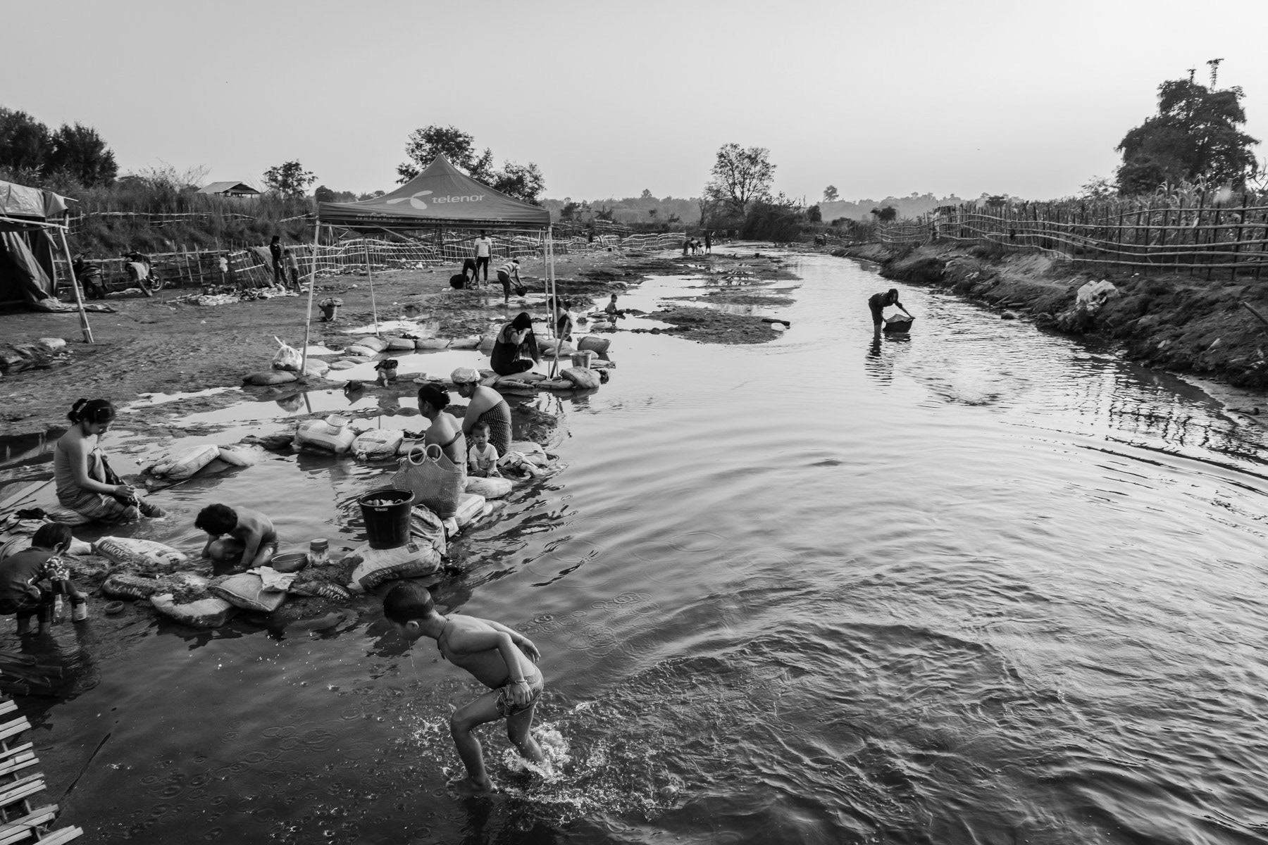 People bathing and washing clothes at a warm water source in Momauk, Kachin State, Myanmar, February 2020