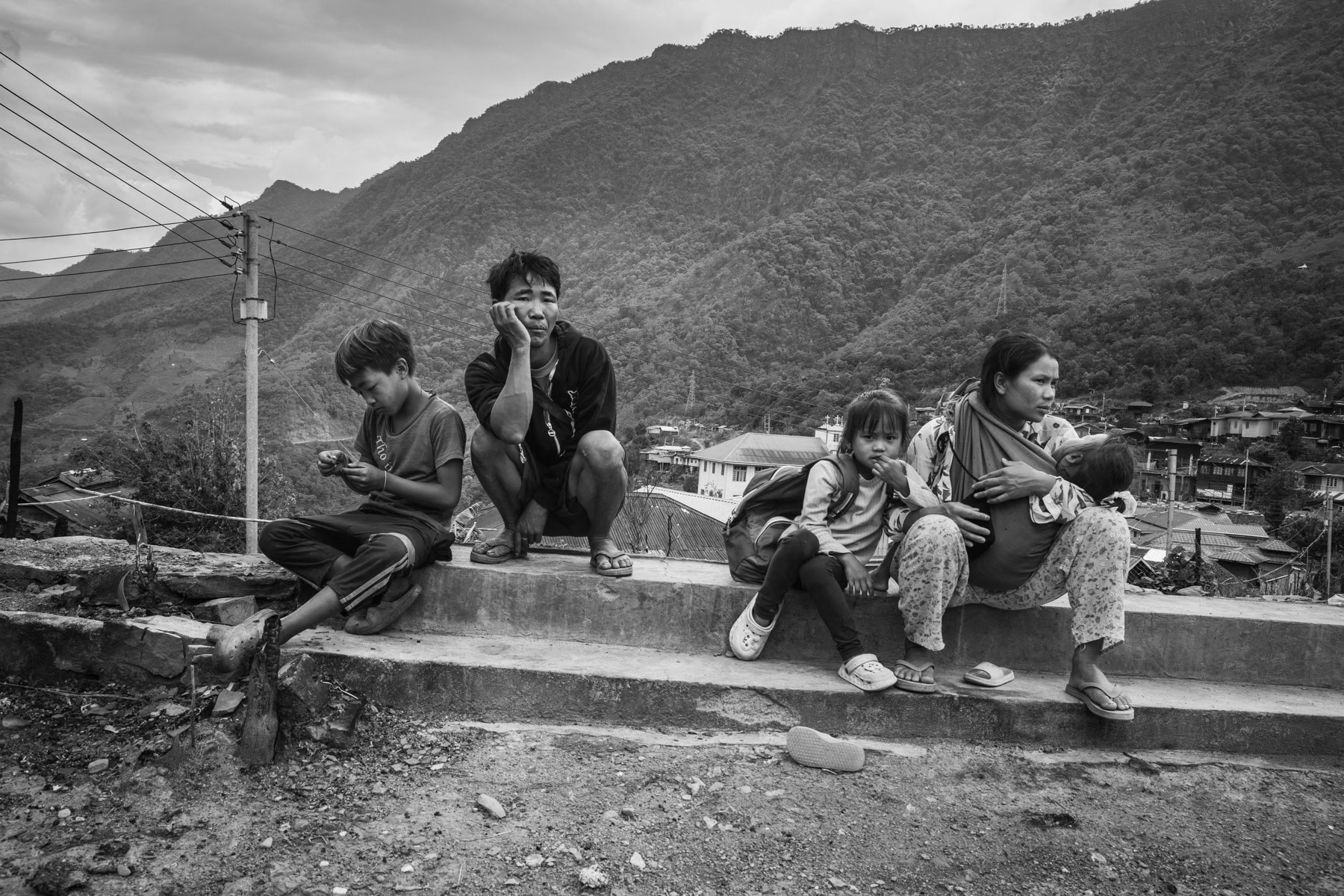 Chin villagers in Ramlau village on the main road between Falam to Hakha. The village was ransacked and looted by the Myanmar military (Tatmadaw) during the passage of their militarty convoy going through Chin State. The military convoy was attacked continously by Chin Defense Forces (CDF) and Chin National Defence Forces (CNDF), the Myanmar military took revenge actions by burning and exploding 19 houses in Ramlau and ordering airstrikes. The population had already evacuated the village a couple of days before the passage of the convoy. Ramlau has 850 habitants, 3 weeks after the raids and airstrikes barely 50% of the population has returned from hiding in the hills and surrounding farms. The airstrikes which are still a high risk targetted the school building sheltering IDPs. Tatmadaw stayed 4 days in the village until 7 May 2023, during which they looted and burned houses. Ramlau village, Falam township, Myanmar, May 2023