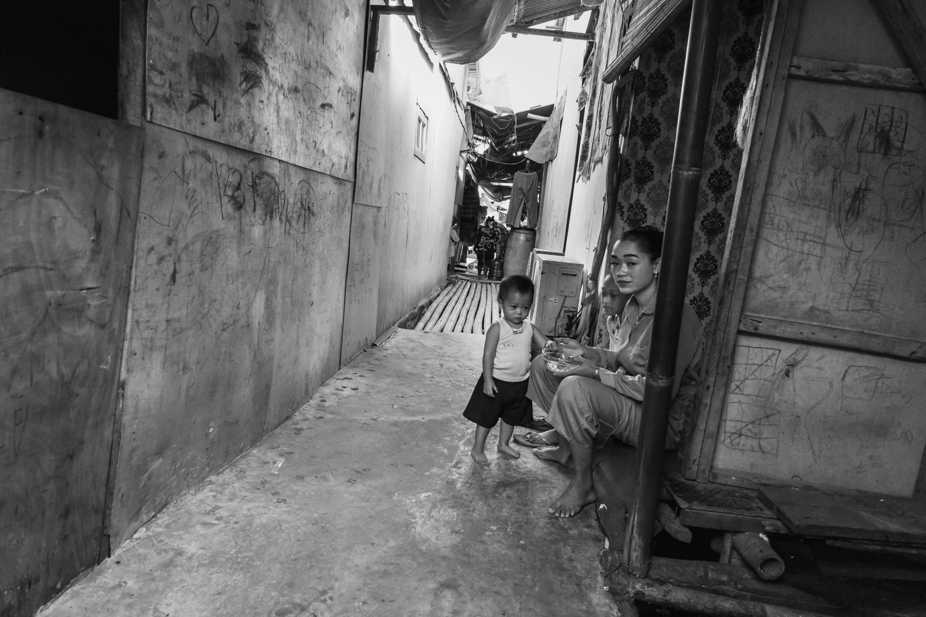 Temporary housing for people evicted from their lands where new infrastructure and real estate projects are being developped. Land rights and land ownership is a big problem affecting mainly poor families from the fishing community. Soil sinking, rising sea levels and floods make their living conditions and survival even more precarious. Muara Angke neighbourhood, North Jakarta, Indonesia, June 2022