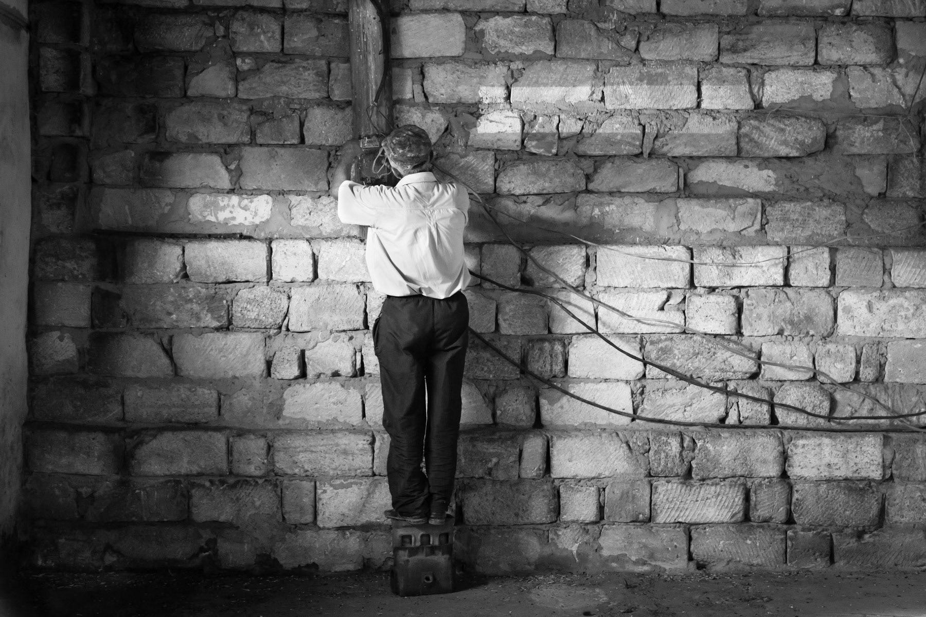 A worker fixing the electricity in the warehouse of a family farm in Okhch, Nagorno-Karabakh, July 2014