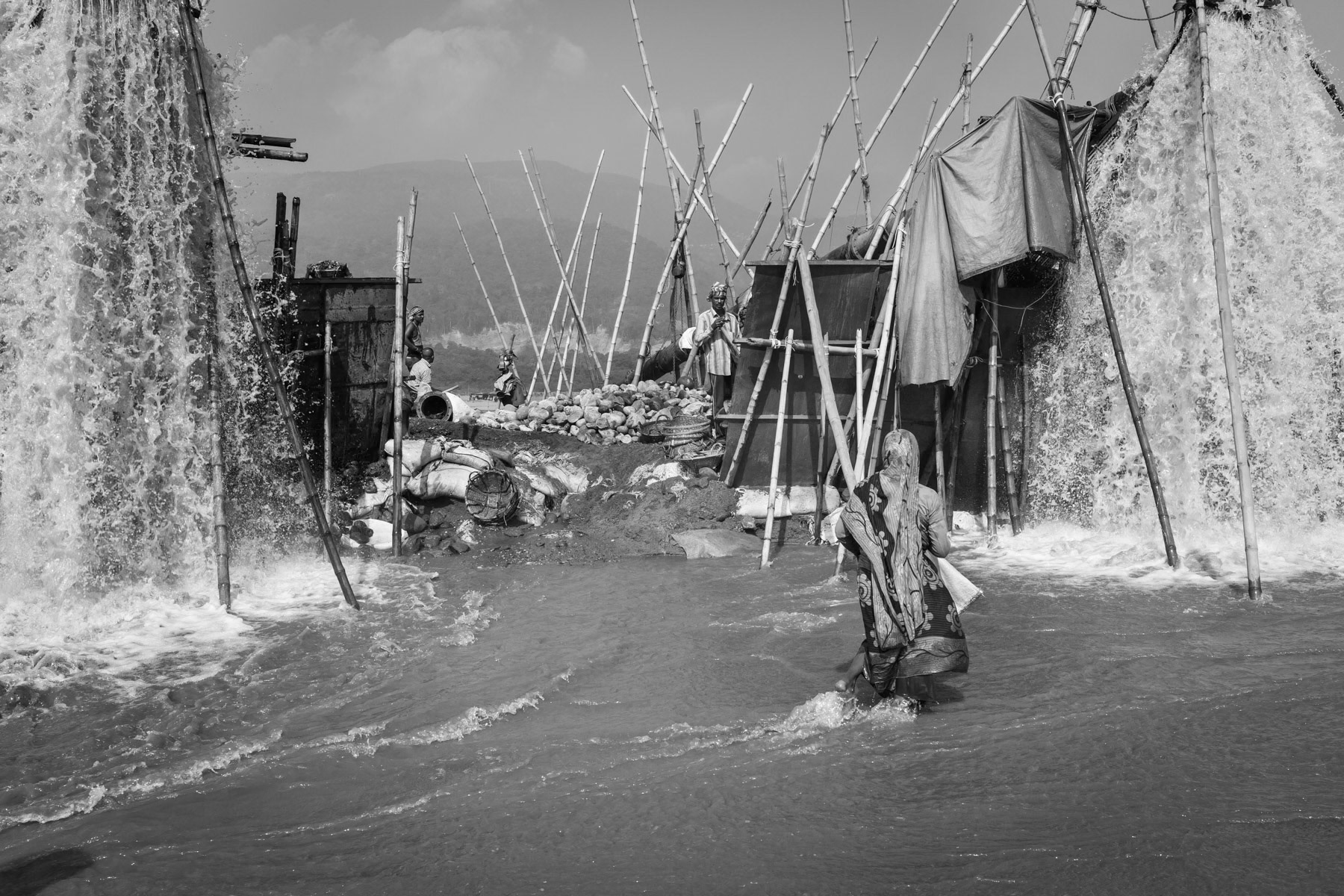 Extraction pumps spilling out water containing stones that are essential to supply the booming construction sector, Dholai river, Bangladesh, December 2015