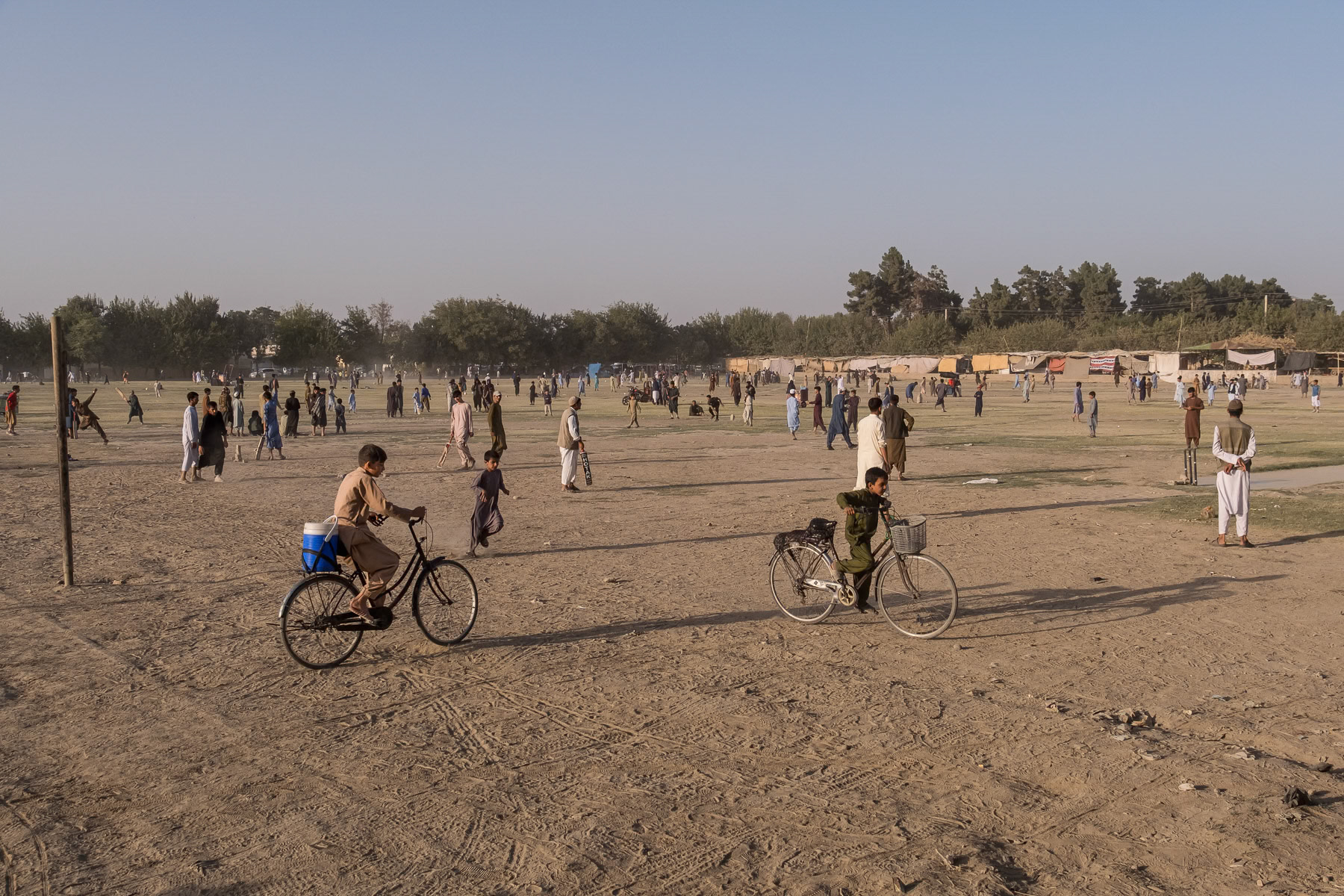 Friday afternoon leisure with children and male adults playing sports on an open field in the northern city of Kunduz, Afghanistan, September 2024