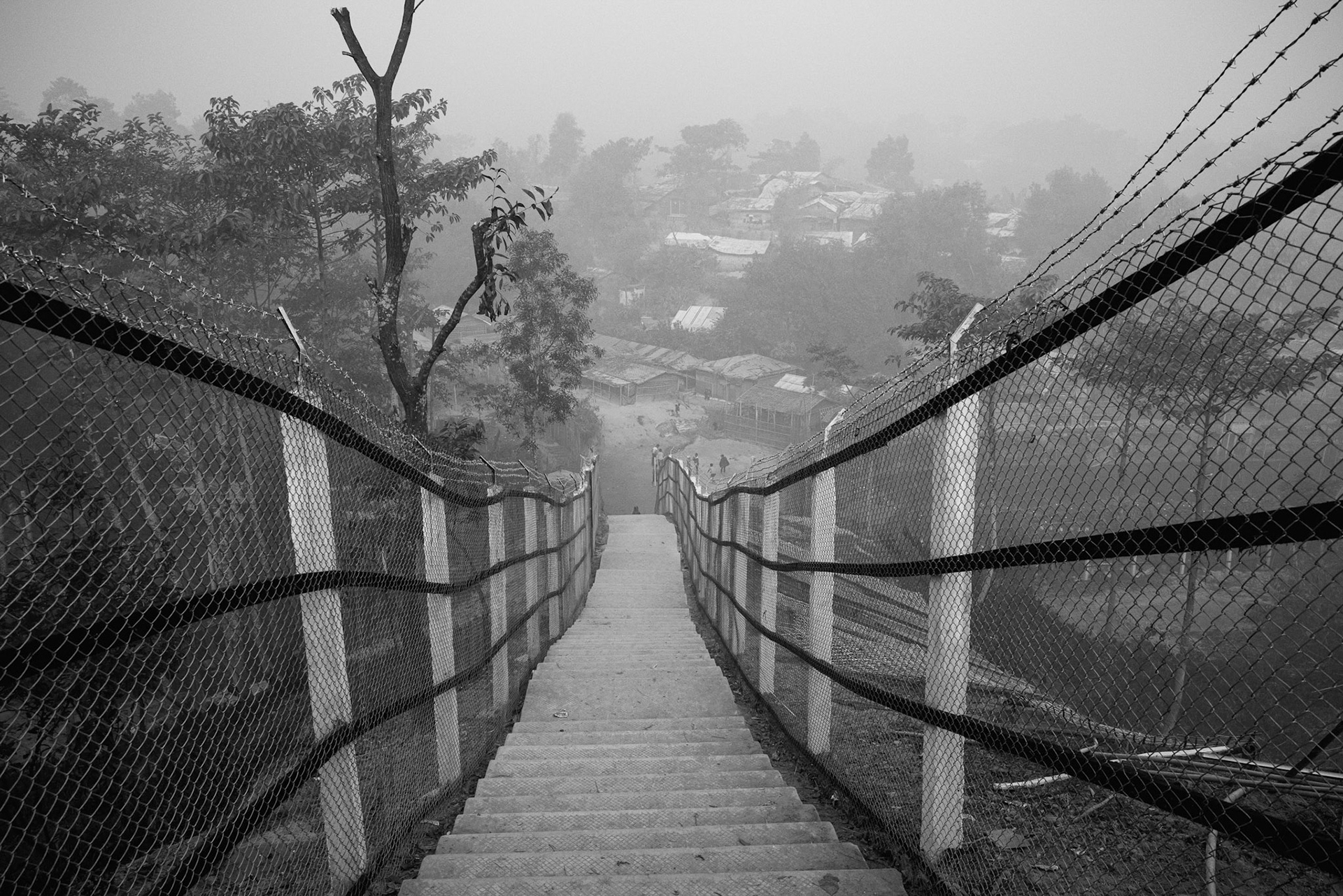 To manage the overcrowding, shelters are built on precarious hillsides, requiring extensive "site-maintenance" projects to prevent landslides during the monsoon season. Kutupalong camp, Bangladesh, January 2026