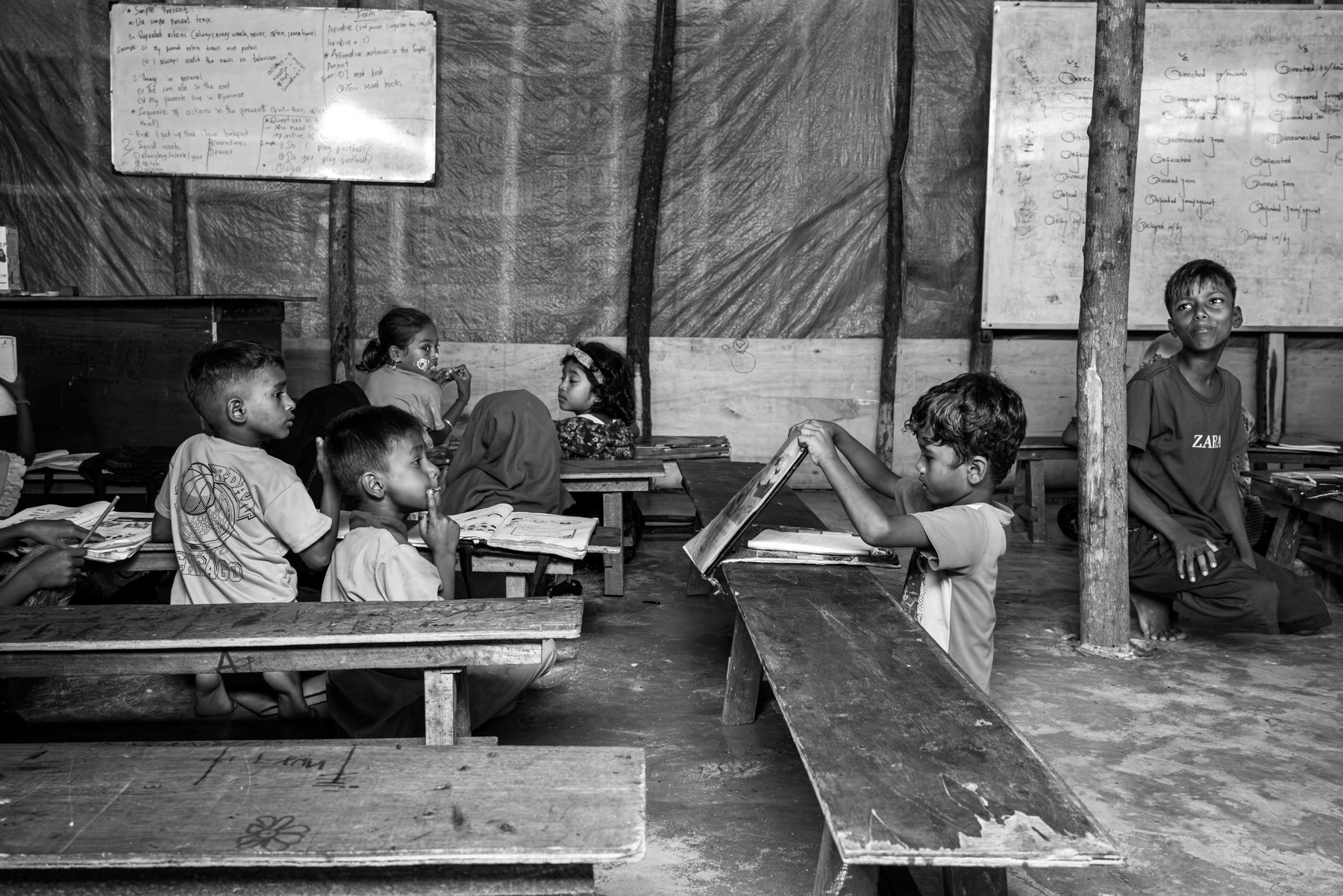 Young Rohingya student takes part in informal lessons organized by the community, offering children a rare chance to learn despite being excluded from local school. Rohingya refugee camp in Pekanbaru, Indonesia, October 2025