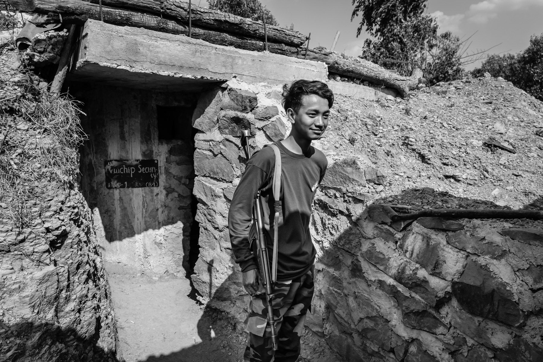 Member of the Chin Defense Forces (CDF) in front of a bunker near the frontline. Vui Chip CDF outpost, Thantlang, Myanmar, April 2024