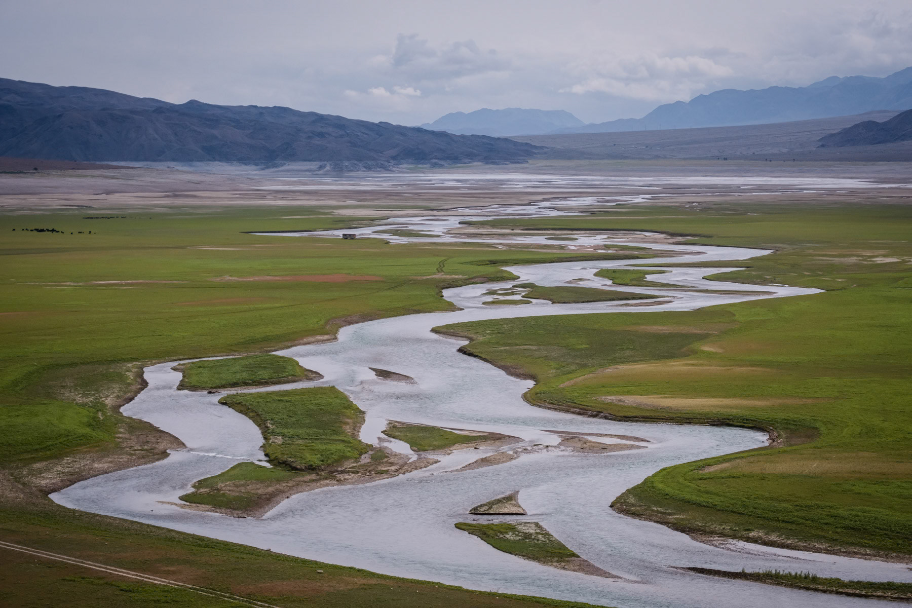 Chu river flowing through an empty Ortotokoy reservoir. Due to a prolonged and recurrent drought in Central Asia and in particular in mountanious Kyrgyzstan, rivers and their water volume have decreased dramatically , jeopardizing the production of electricity and agriculture yield in the countries further down the rivers. Ortotokoy reservoir, Issyk Kul region, Kyrgyzstan, August 2021