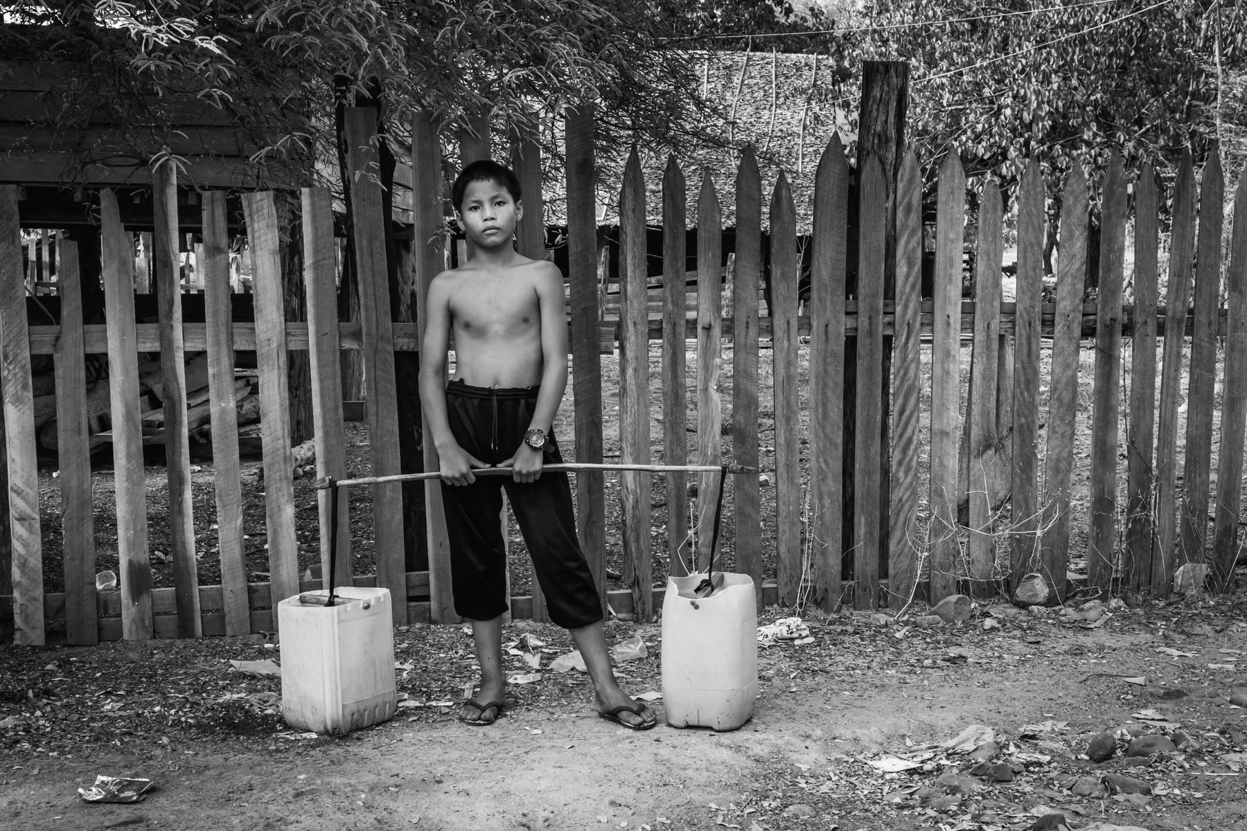 Karen boy carrying water, Lae Gho village in Karen State, Myanmar, May 2024