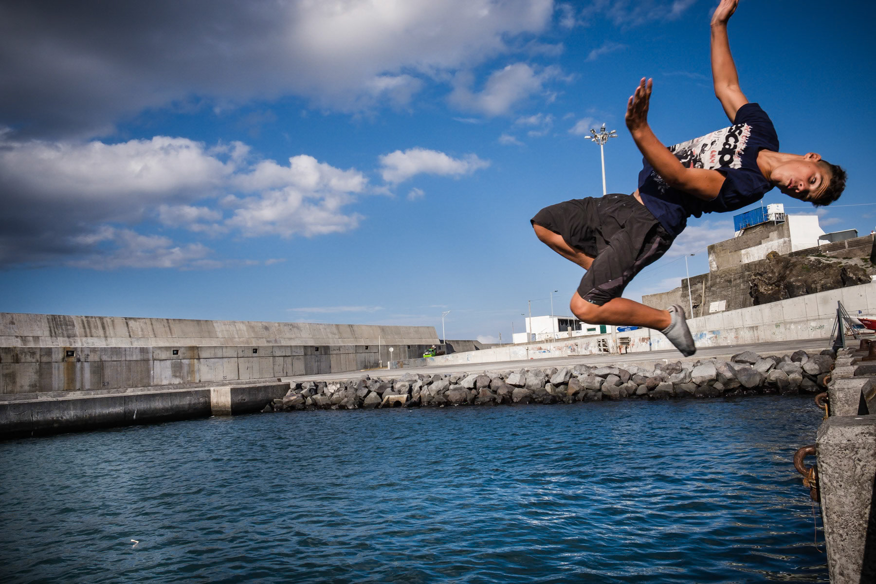 Kids playing and swimming in the port. Rabo de Peixe, Azores, September 2018