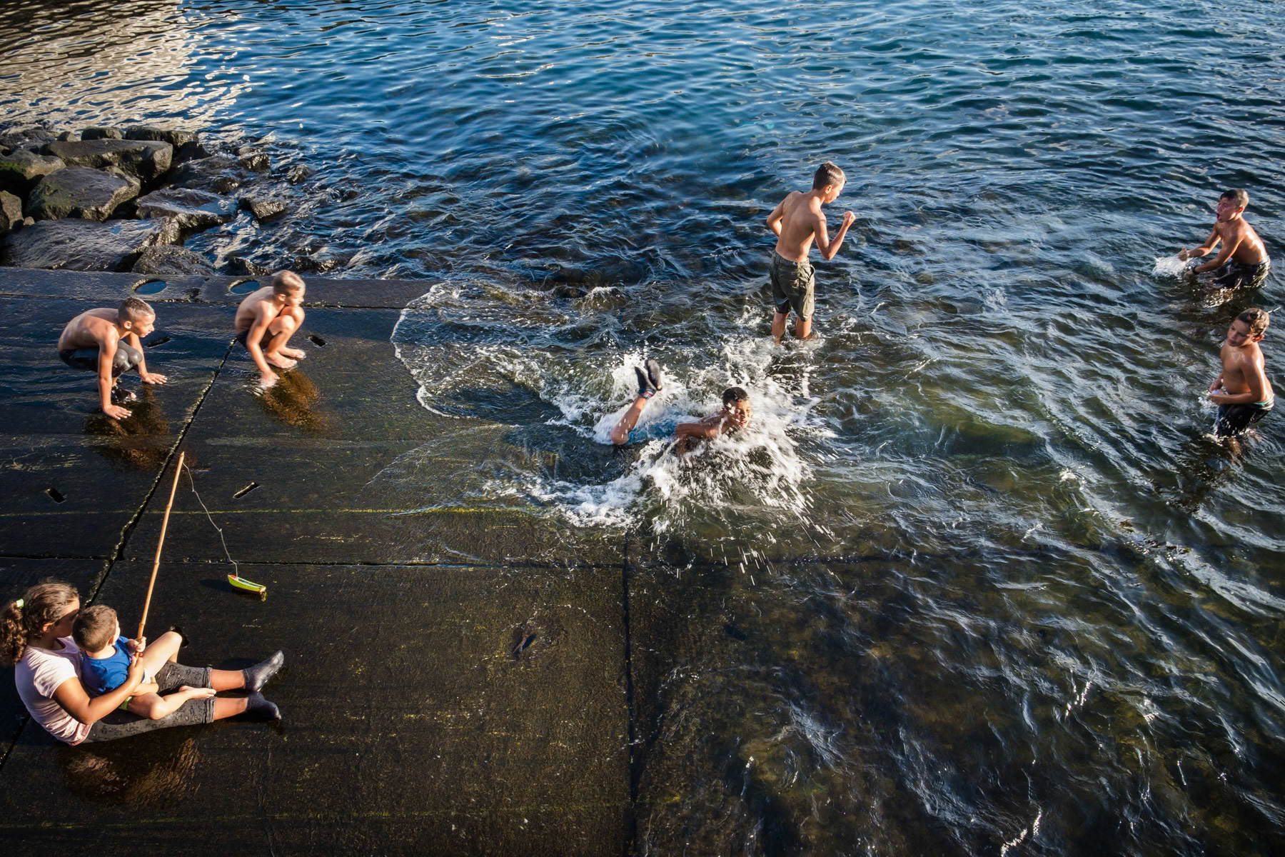 Kids playing and swimming in the port. Rabo de Peixe, Azores, September 2018