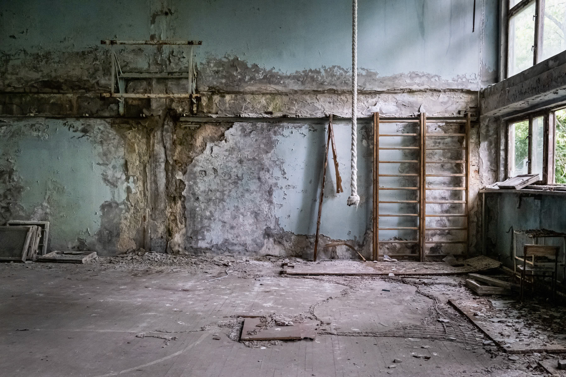 School sporthall in Pripyat town. The town was developed alongside the nuclear power plant to house staff and their families. Before the disaster it consisted of 5 districts, each of them with well-developed infrastructure. There were 5 schools, 14 kindergartens, a cinema, swimming pools, theatre, shopping centres and residential buildings for 30,000 people with extensions planned of at least one more district near the port area. The complete population of Pipyat was evacuated 36 hours after the disaster to never return again. Pripyat is now an overgrown ghost town where time stood still on 27 April 1986. Pripyat, Chernobyl NPP, Ukraine, June 2021