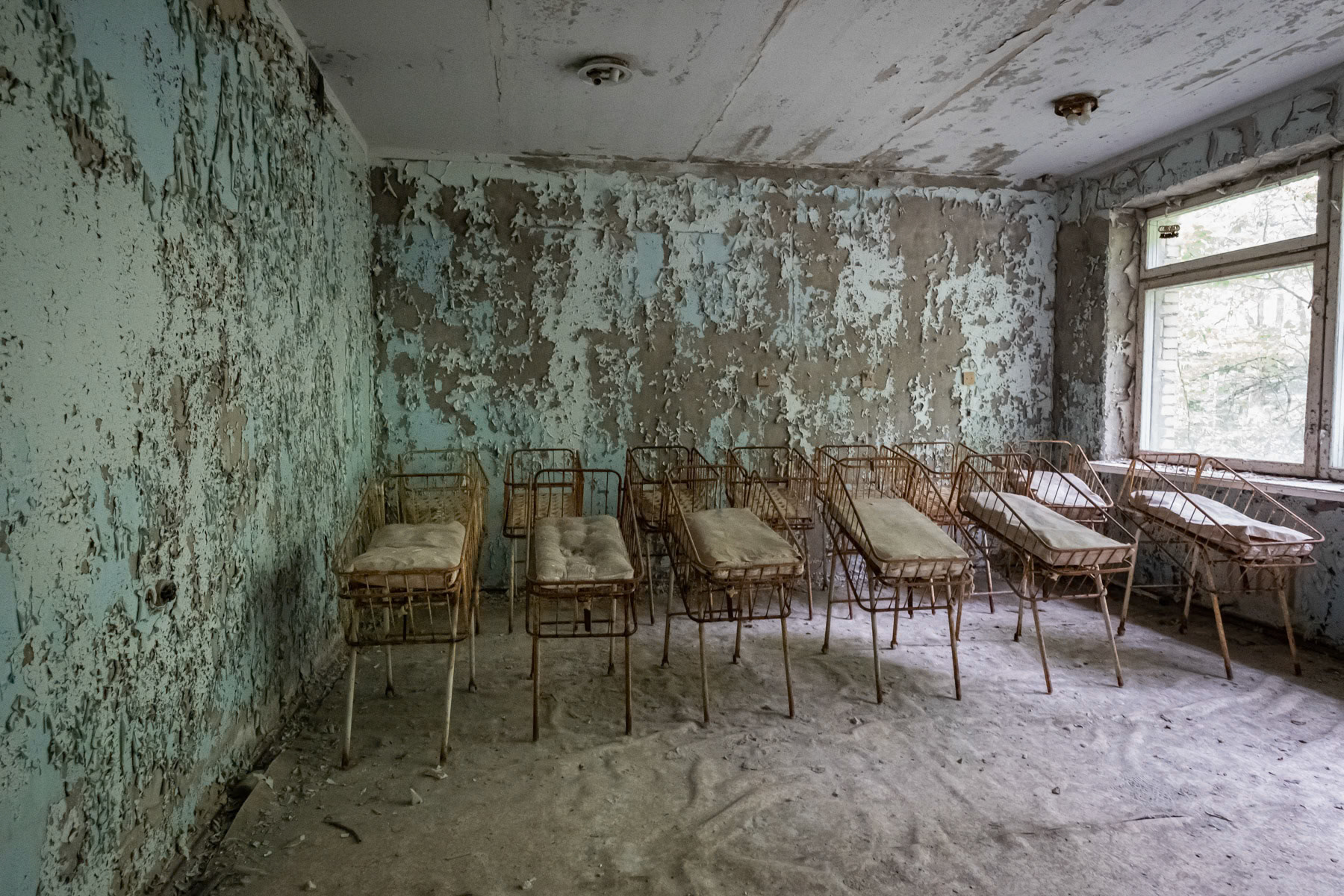 Maternity ward of the Pripyat hospital. The town was developed alongside the nuclear power plant to house staff and their families. Before the disaster it consisted of 5 districts, each of them with well-developed infrastructure. There were 5 schools, 14 kindergartens, a cinema, swimming pools, theatre, shopping centres, a large hospital and residential buildings for 30,000 people with extensions planned of at least one more district near the port area. The complete population of Pipyat was evacuated 36 hours after the disaster to never return again. Pripyat is now an overgrown ghost town where time stood still on 27 April 1986. Pripyat, Chernobyl NPP, Ukraine, June 2021