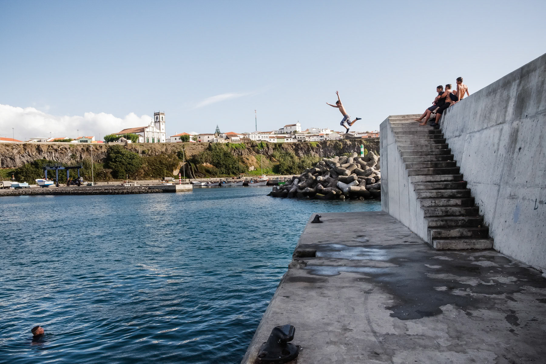 Kids playing and swimming in the port. Rabo de Peixe, Azores, September 2018