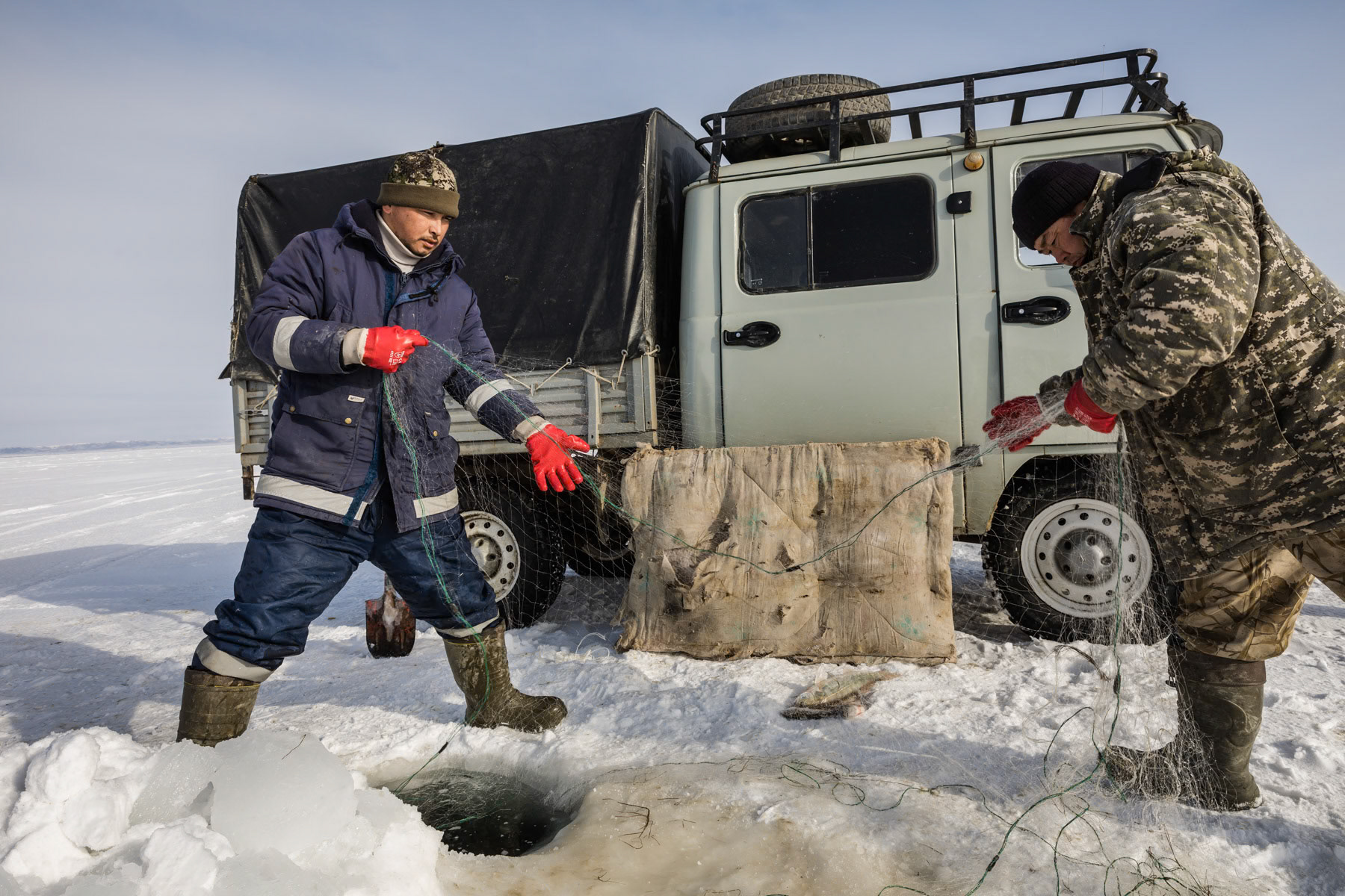 Fishermen at work on the Aral Sea during the ice fishing season. Kazakhstan, January 2019
