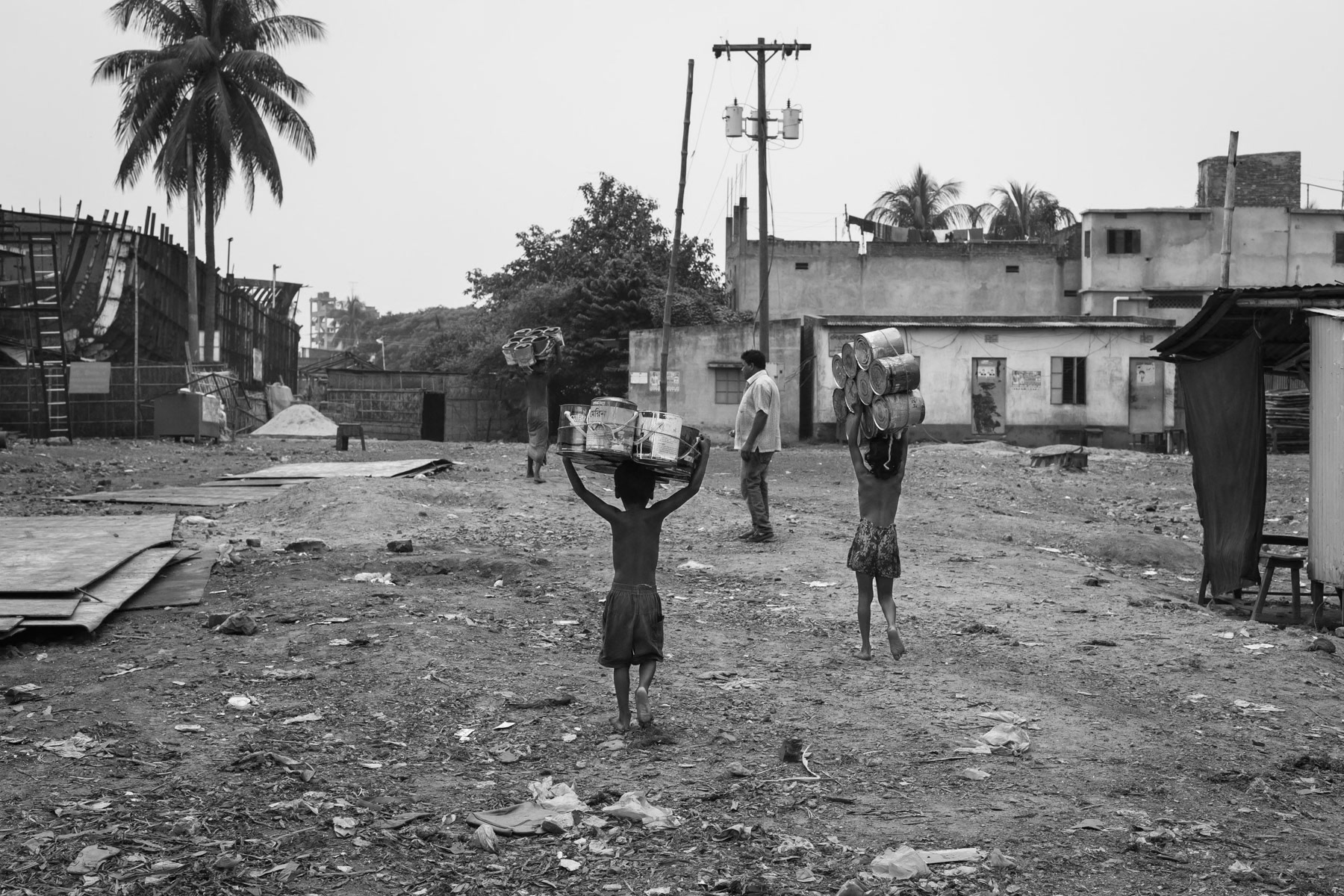 Children carrying empty paint pots collected on the shipyards, Dhaka, Bangladesh, October 2014
