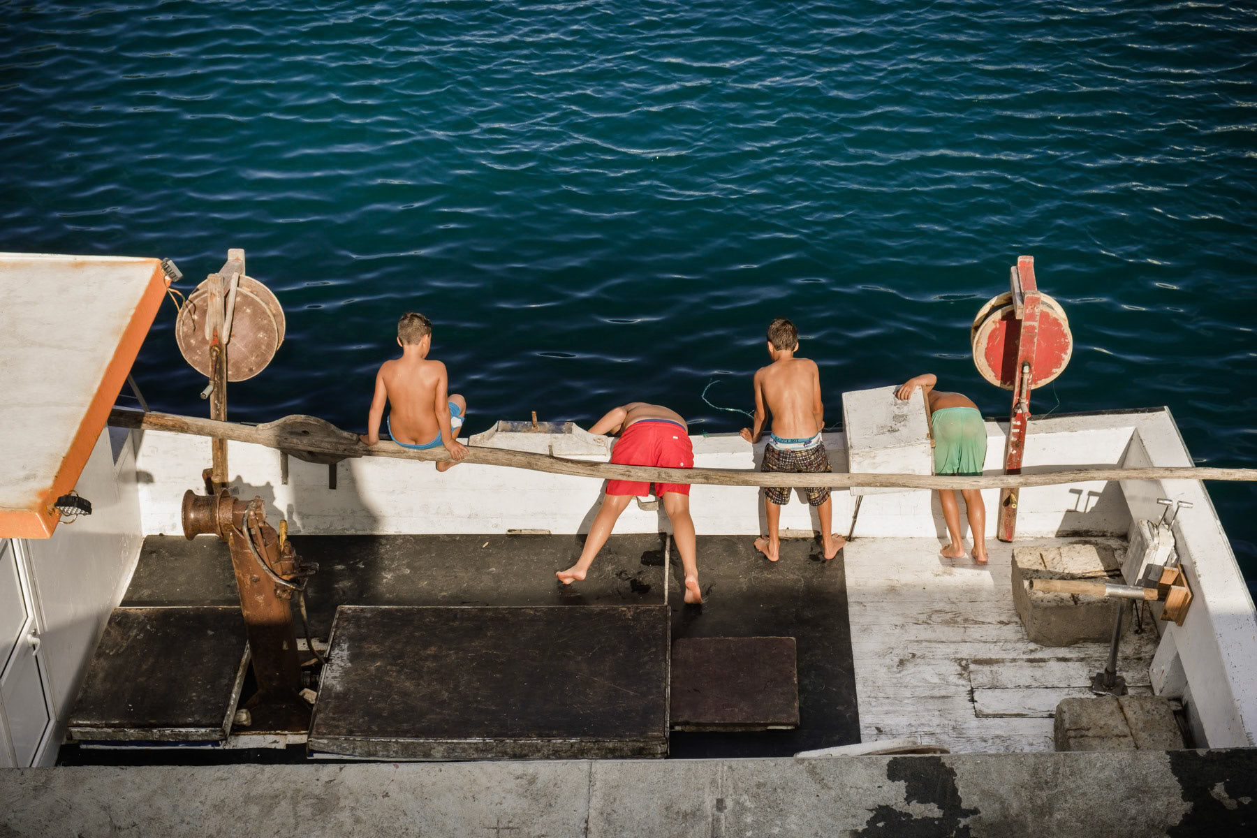 Kids playing and swimming in the port. Rabo de Peixe, Azores, September 2018