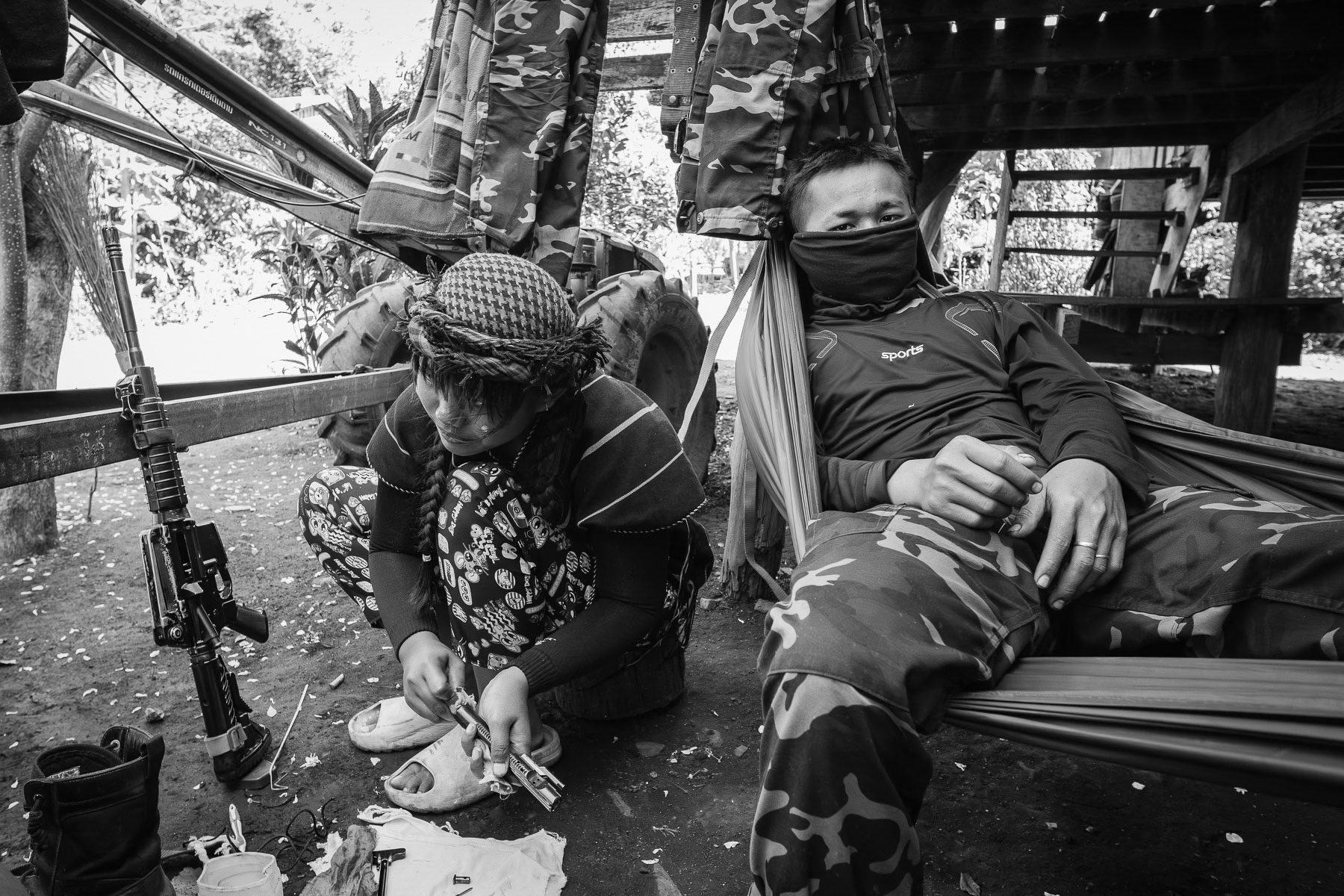A Karen soldier of the KNLA cleaning her weapon. Frontline outpost in Karen State, Myanmar, January 2025