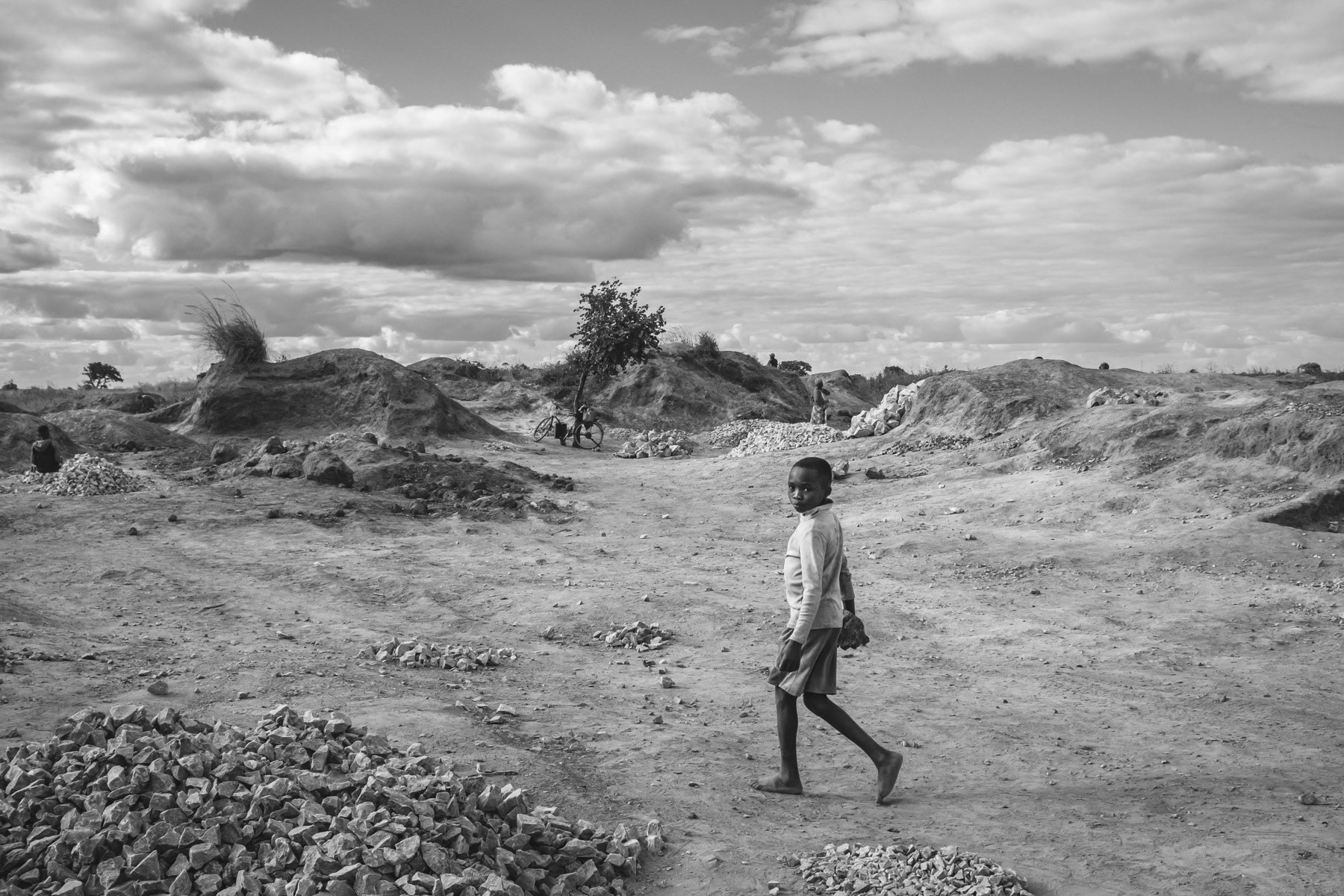 A child working at the Mukululu small scale open pit mine started by the local authorities as a community empowerment project. Mainly lead sulfide and magnesium oxide are being found and bought up by middle men that will make the main profit, the women, men and children from the local community doing the daily hard labour make hardly enough money for their basic food needs. Mukululu community, Kabwe, Zambia, May 2021