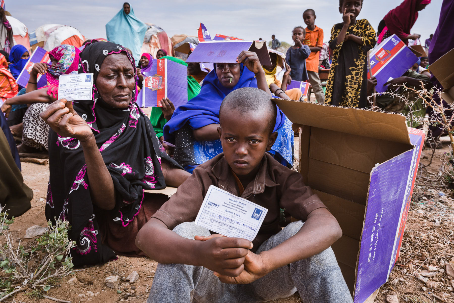 Climate refugees holding their food ration card during one of the two weekly food distributions. Having lost their livelihood due to the drought, these once pastoralists are entirely dependent on food and water distributions to survive. Saraar Region, Somaliland, October 2017
