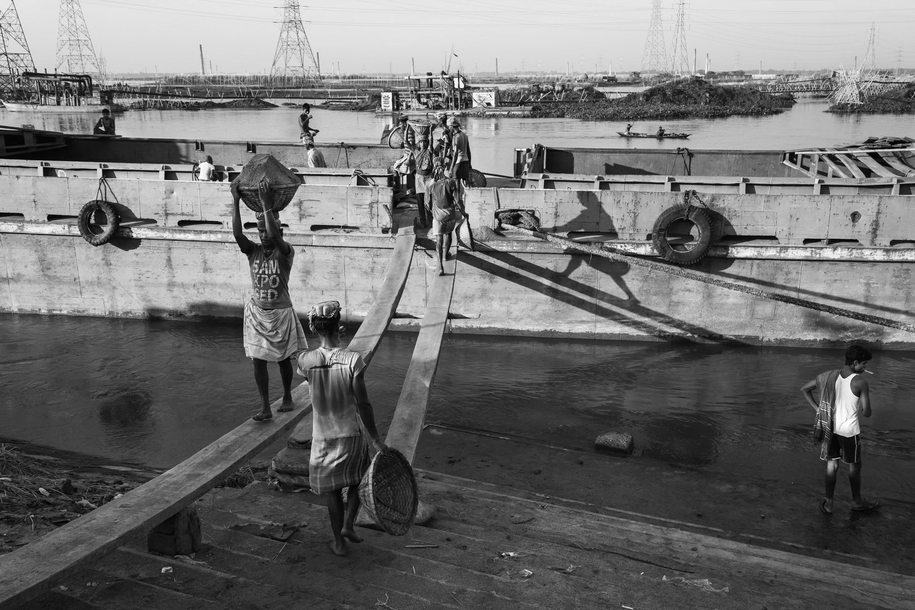 Sand cargo unloading and other morning activities, Gabtoli docks along the Buriganga river, Dhaka, Bangladesh, October 2014