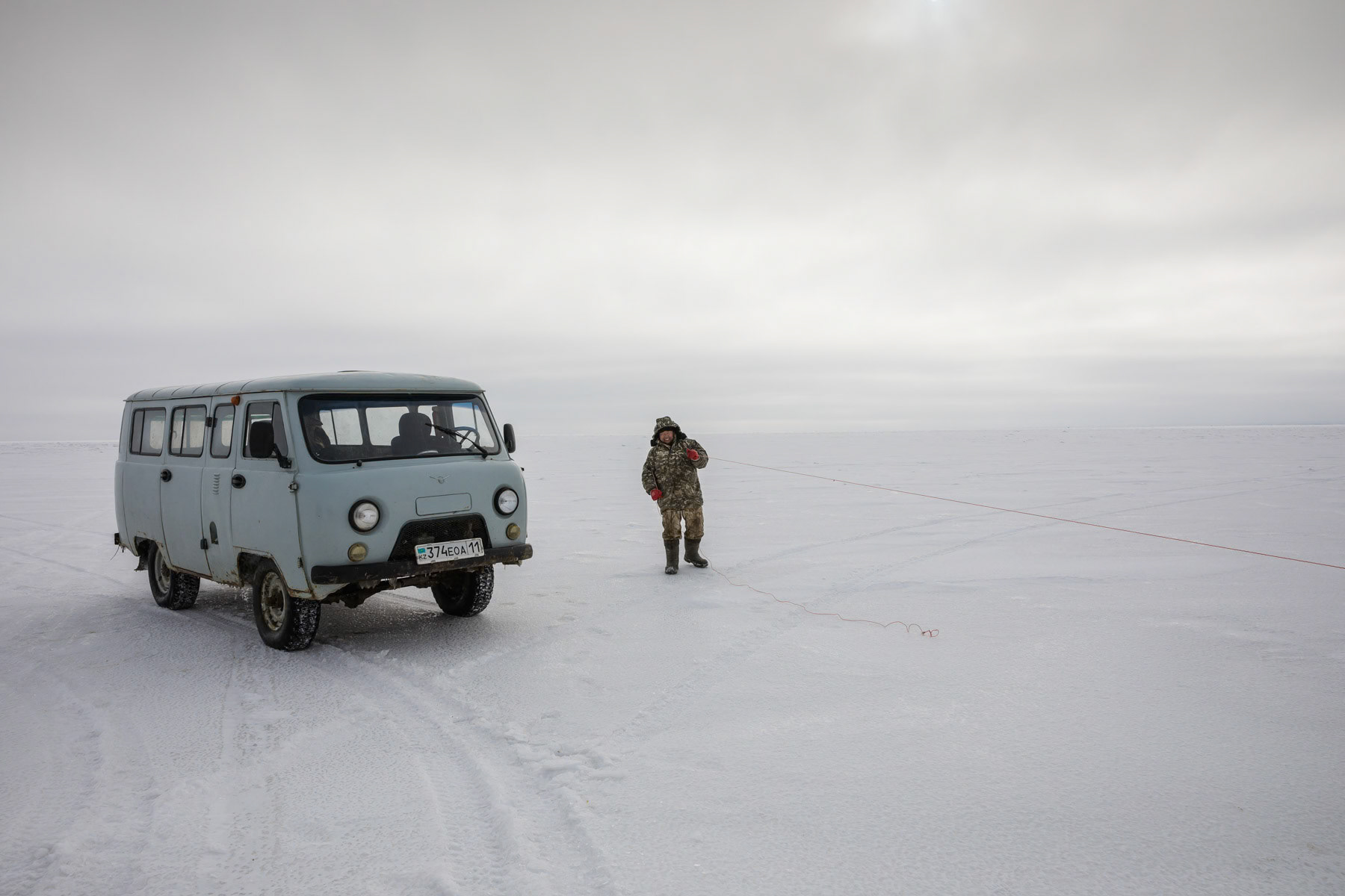 Fisherman on the frozen Aral Sea. The temperatures reach minus 20-30C during winter months and the ice fishing season lasts about 3-4 months. Aral Sea, Kazakhstan, January 2019