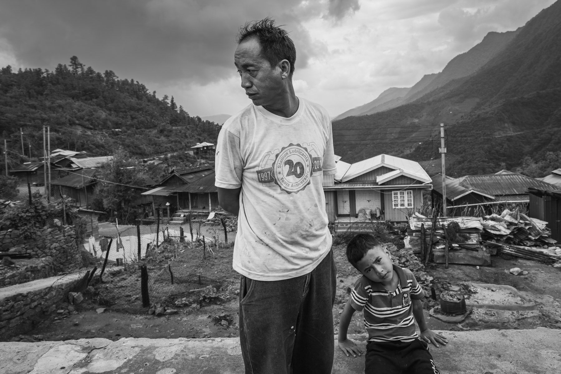 A villager and his son from Ramlau who had his house and belongings burned and destroyed by the Myanmar military 3 weeks ago. Ramlau is a Chin mountain village on the main road between Falam to Hakha. The village was ransacked by the Myanmar military (Tatmadaw) during the passage of their militarty convoy going through Chin State. The military convoy was attacked continously by Chin Defense Forces (CDF) and Chin National Defence Forces (CNDF), the Myanmar military took revenge actions by burning and exploding 19 houses in Ramlau and ordering airstrikes. The population had already evacuated the village a couple of days before the passage of the convoy. Ramlau has 850 habitants, 3 weeks after the raids and airstrikes barely 50% of the population has returned from hiding in the hills and surrounding farms. The airstrikes which are still a high risk targetted the school building sheltering IDPs. Tatmadaw stayed 4 days in the village until 7 May 2023, during which they looted and burned houses. Ramlau village, Falam township, Myanmar, May 2023