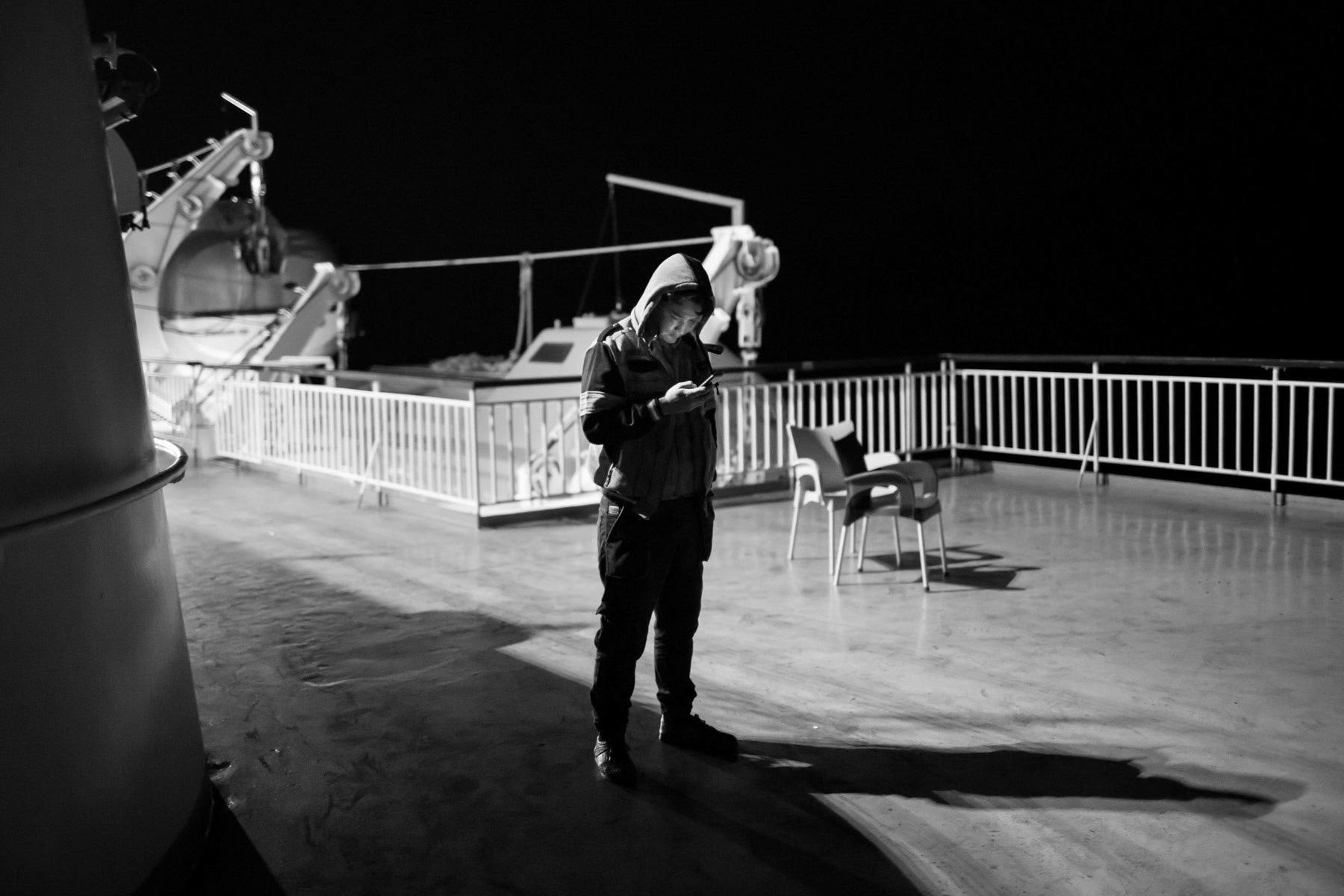 Afghan refugee texting family back home about his whereabouts, Levbos-Athens ferry, November 2015