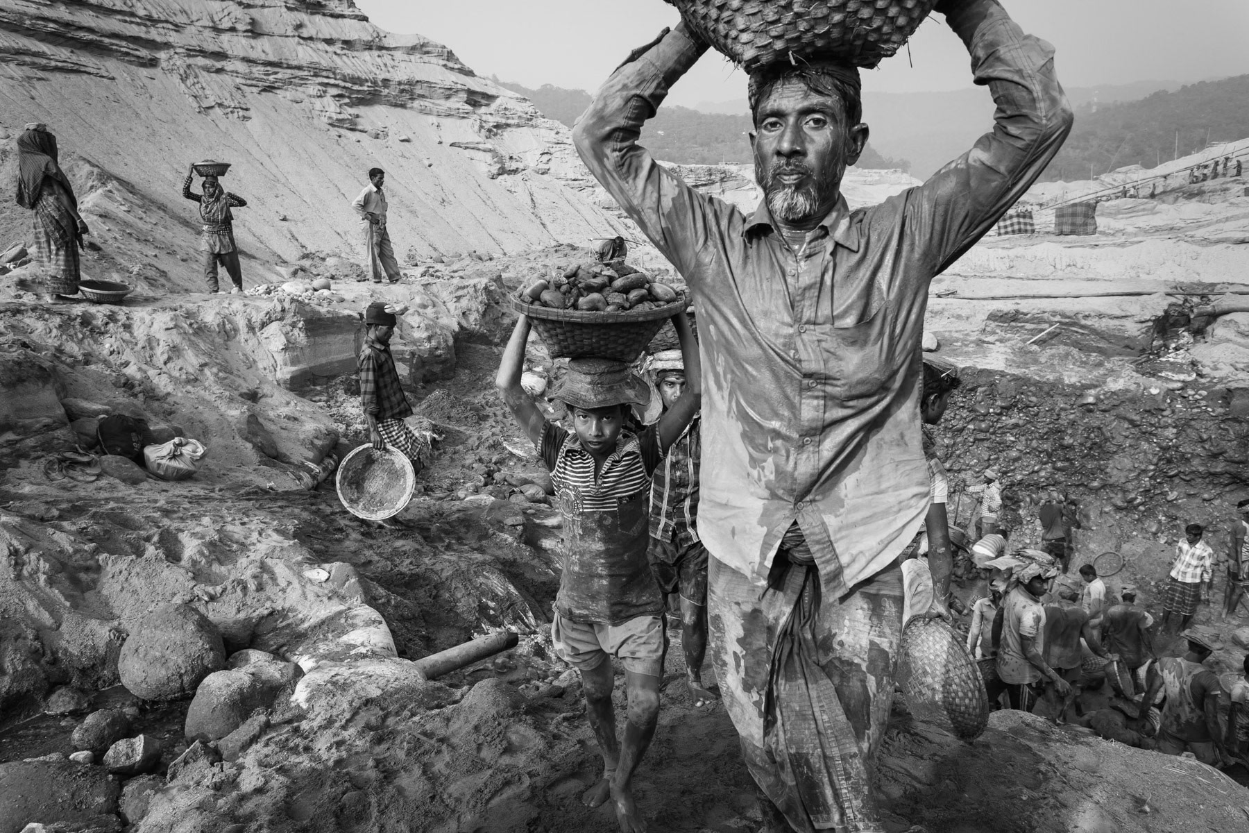 Seasonal migramt workers extracting stones from the river bed during the dry season, Tamabil in Bangladesh, December 2015